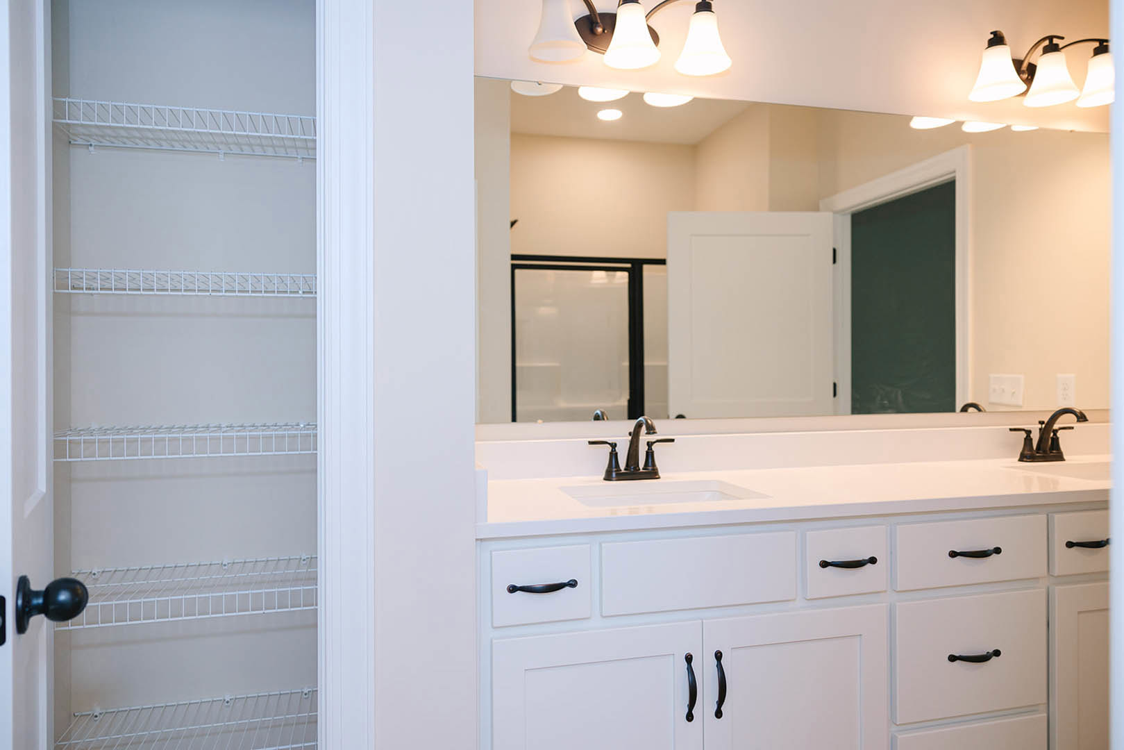 Modern bathroom featuring a rectangular mirror above a white sink with chrome faucet, light gray tile backsplash, and built-in cabinetry.