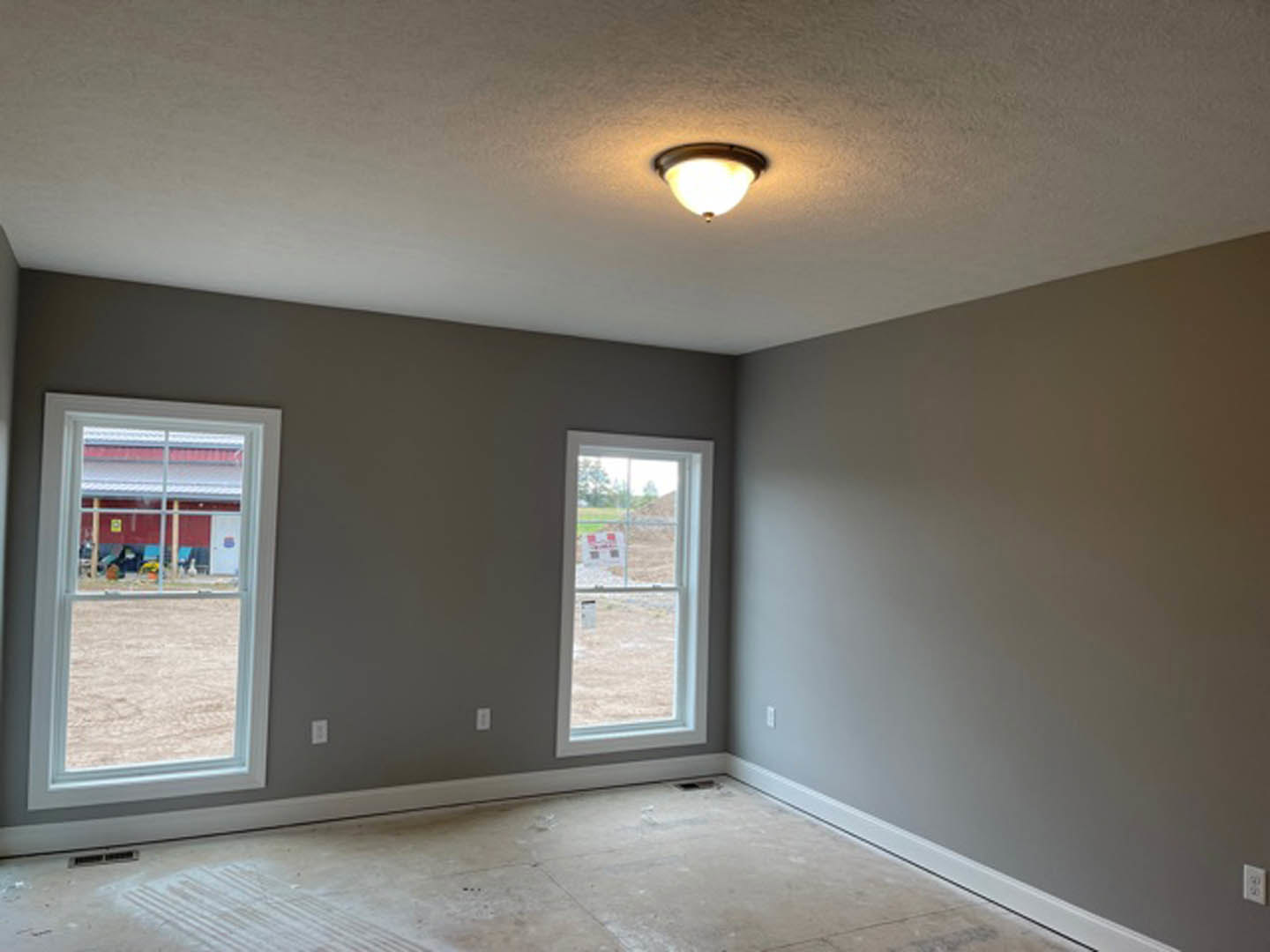 Bright room with large windows, white tile flooring, recessed ceiling light fixture, and unfinished wall opening