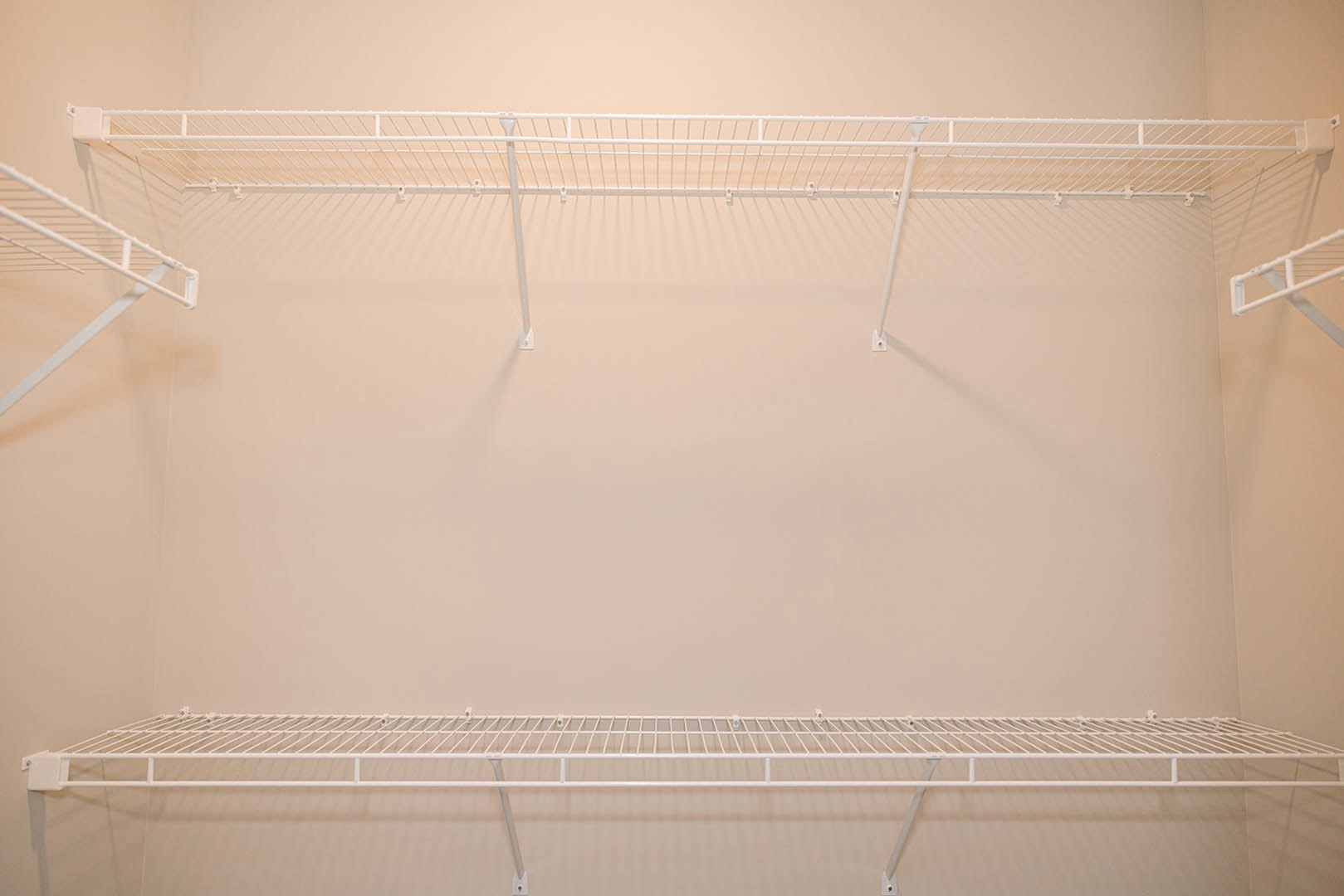 White wire shelf mounted on a smooth white wall in a residential interior.