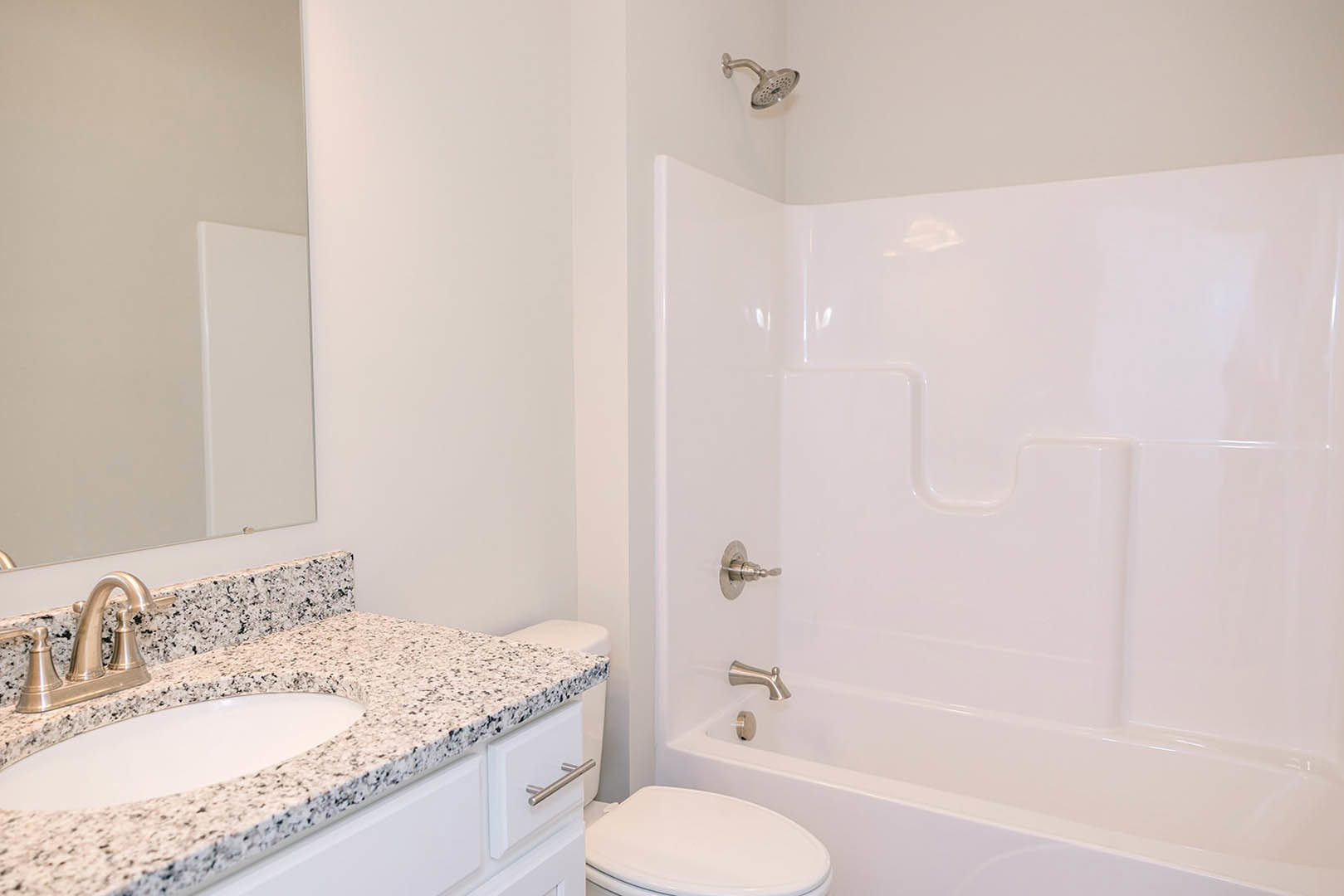 Modern bathroom featuring a white toilet, marble countertop with vessel sink, chrome faucet, tiled walls, and glass-enclosed shower.