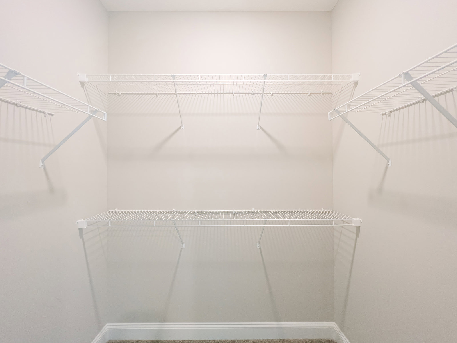 White built-in shelves with decorative molding on a white plaster wall in a residential interior room.