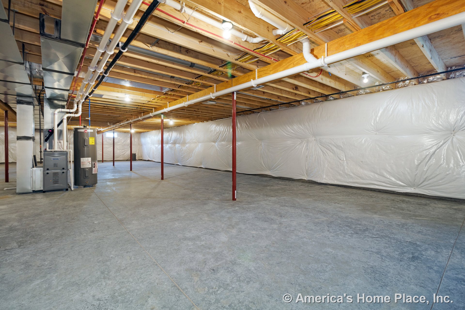 Unfinished basement with exposed ceiling joists, visible ductwork and HVAC system, concrete flooring, plastic wall insulation, structural support columns, and overhead lighting