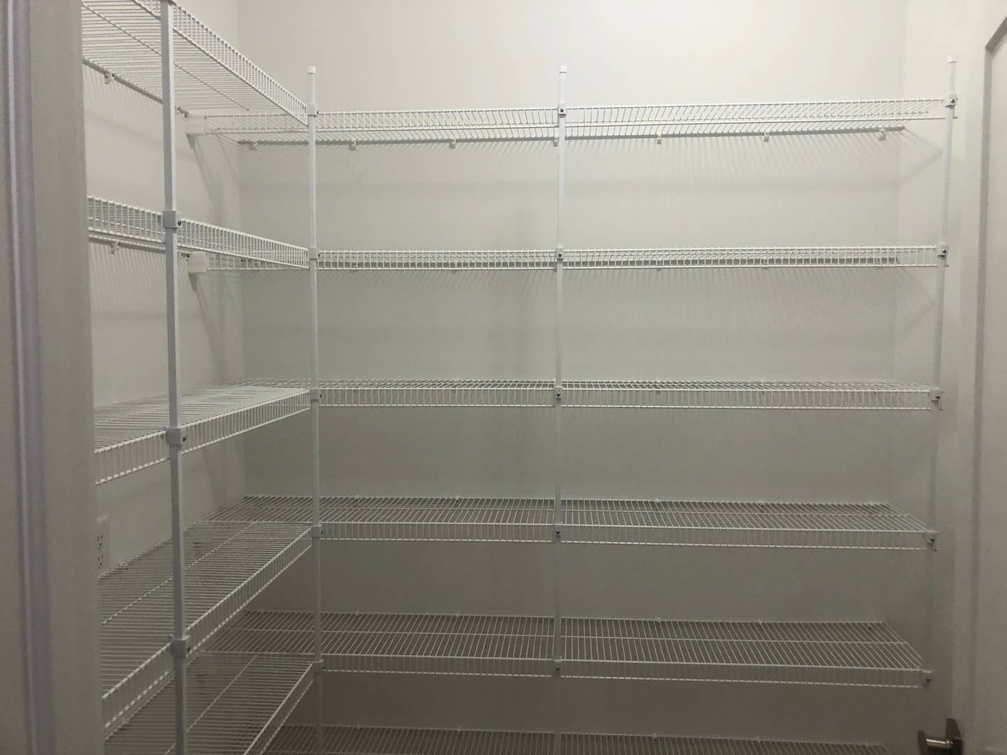 White wire shelving with metal rod mounted on a light-colored wall in a residential room.