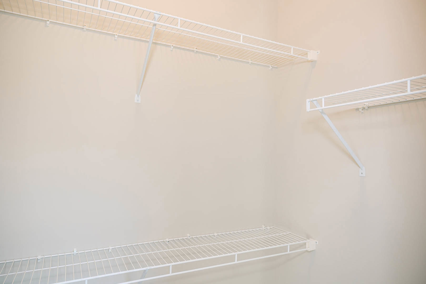 White wire shelving mounted on a white wall in a bright indoor room