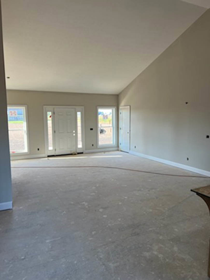 White-painted wall and white door with glass panels, light-colored flooring, simple ceiling, minimal interior detailing