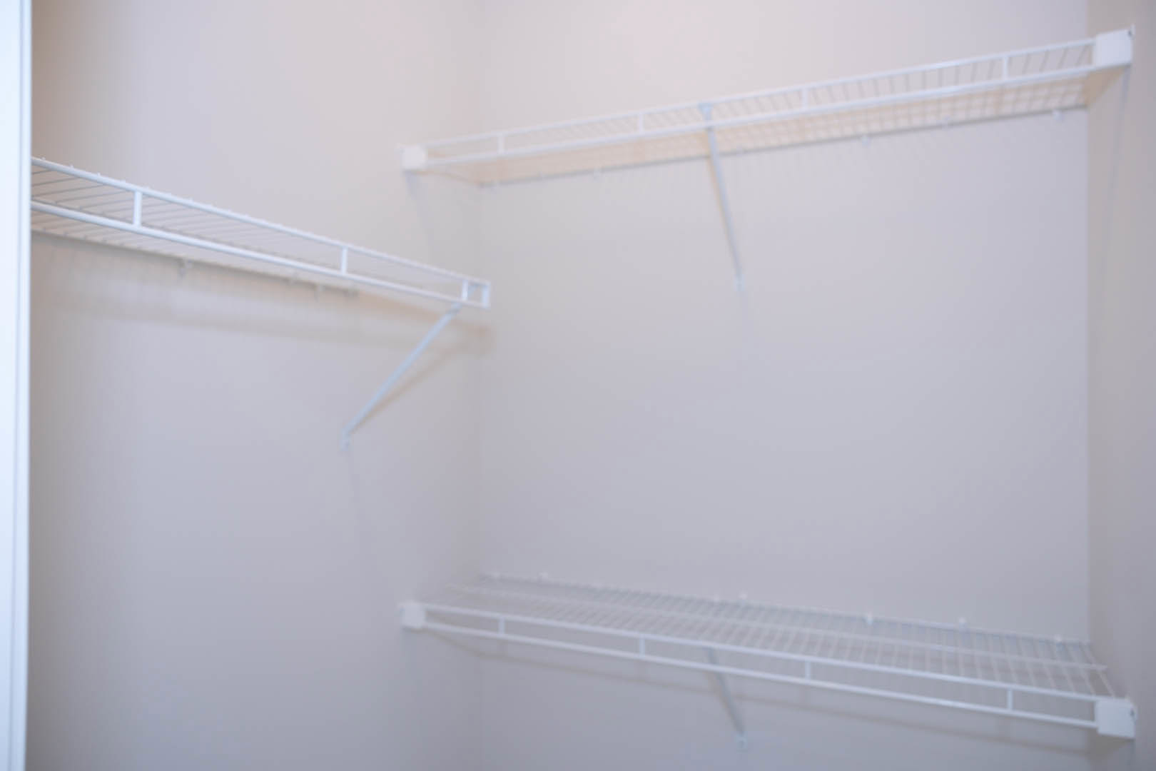 White built-in shelves with a smooth plaster finish against a wall in a softly lit room