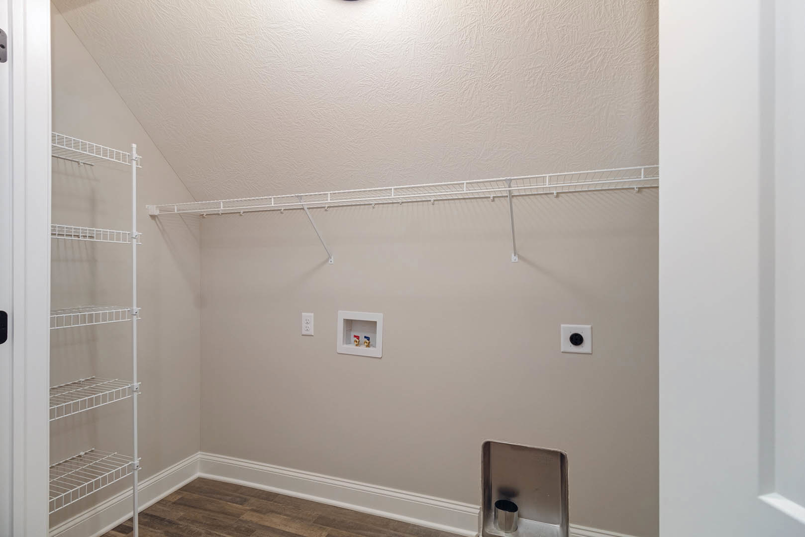 Walk-in closet with white shelves, overhead light fixture, and visible plumbing access panel featuring red and blue valves on the wall.