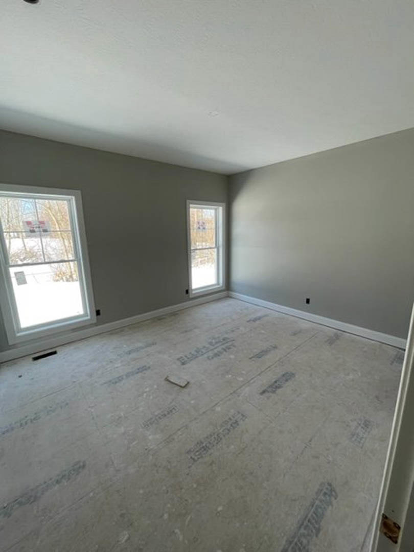 Spacious room with smooth white floor, large windows with white frames, plaster walls, and ceiling, natural daylight streaming in