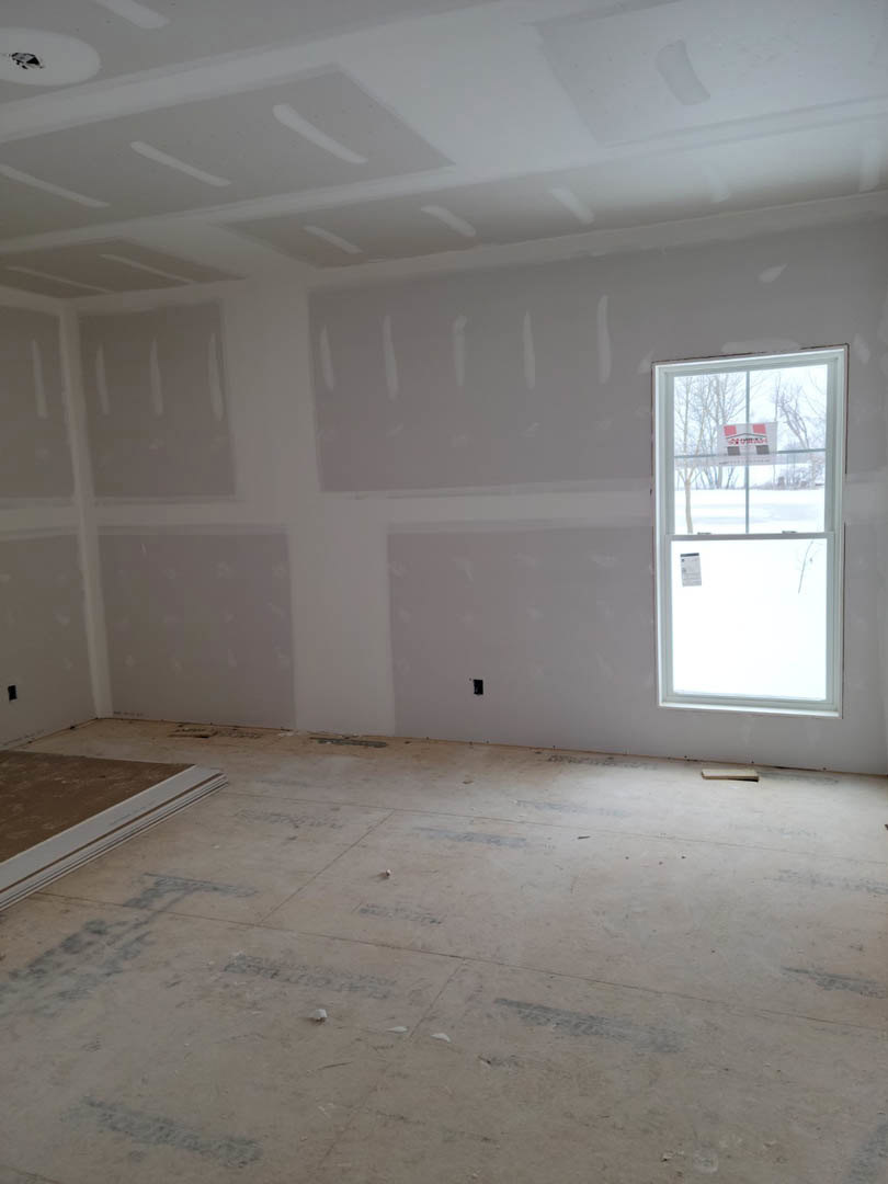 White-walled room with a large window, light-colored tile flooring, and smooth plaster finishes.