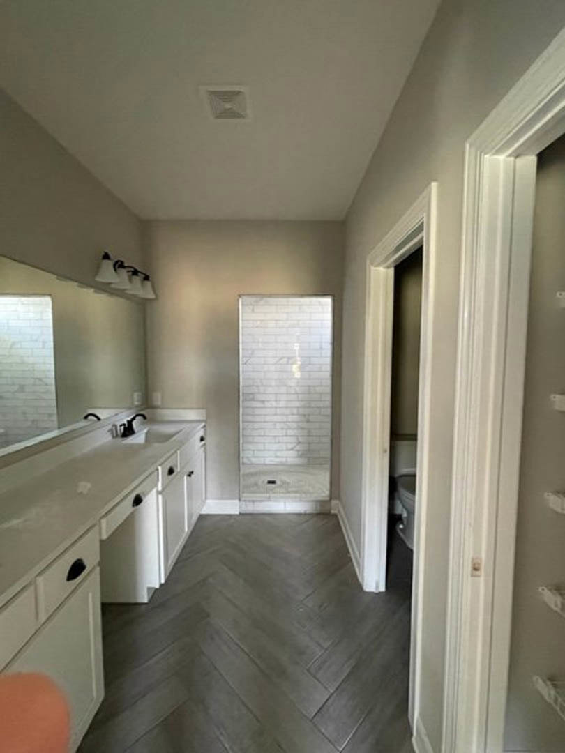 Modern bathroom featuring a glass-enclosed shower, white subway tile walls, floating vanity with integrated sink, quartz countertop, and recessed ceiling vent.