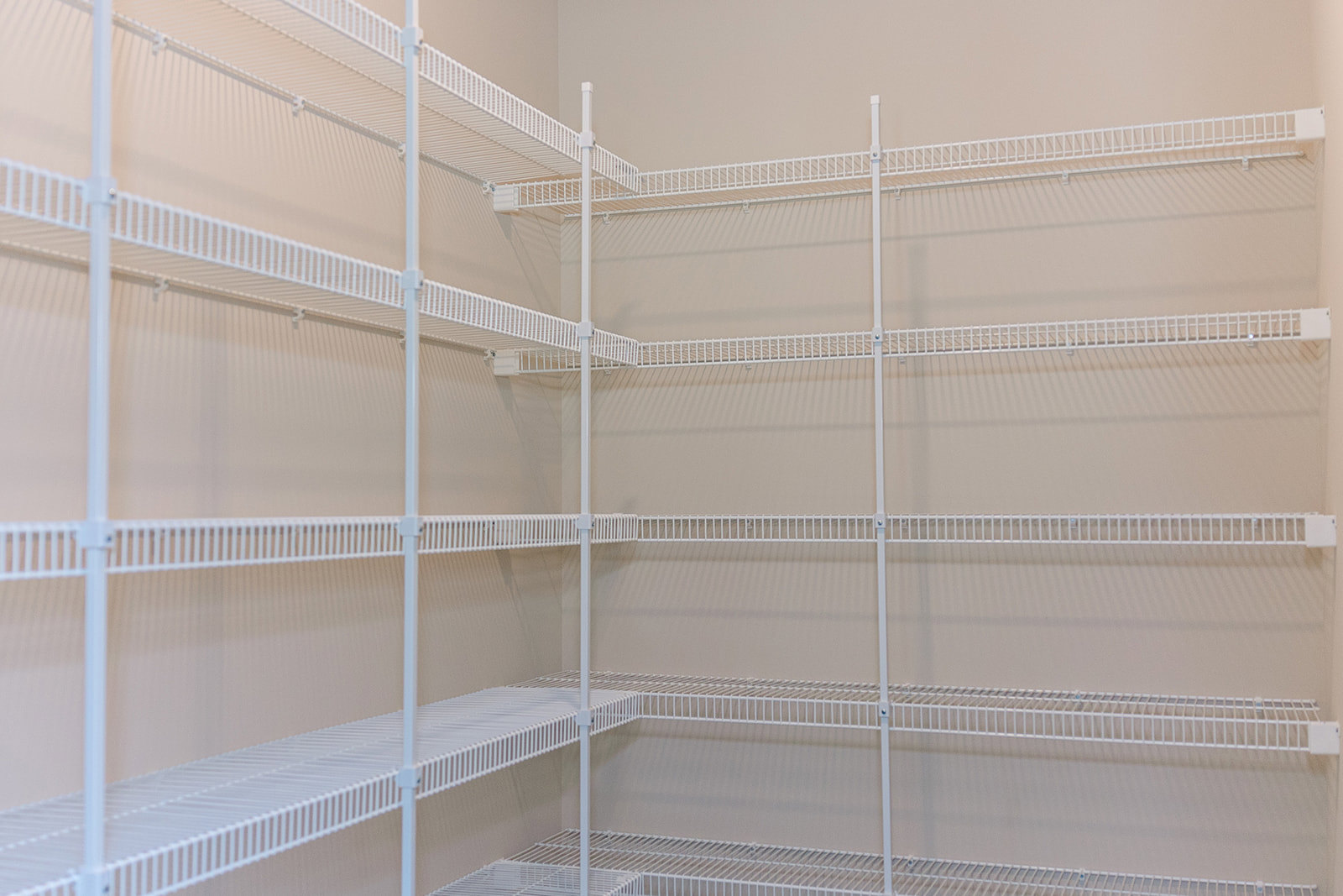 White built-in shelving unit against a smooth white wall in a modern indoor room, featuring clean lines and minimalist design.