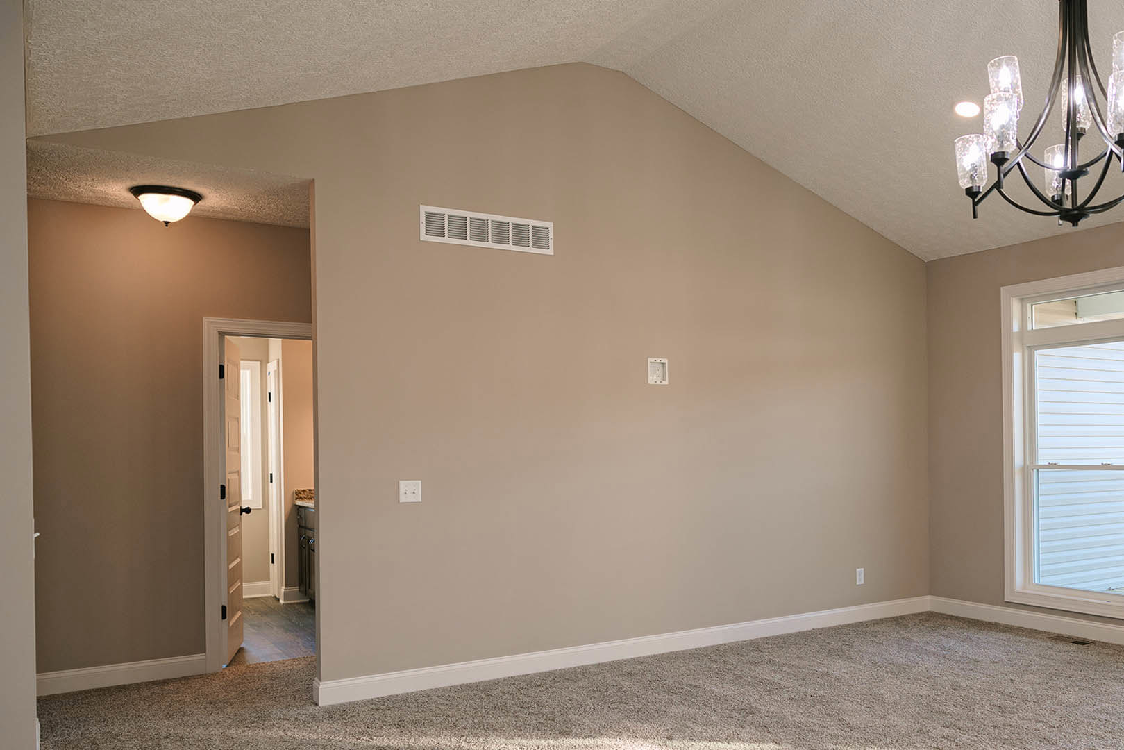 White plaster walls, wood flooring, ceiling fan, recessed lighting, and a paneled door in an open kitchen and living area