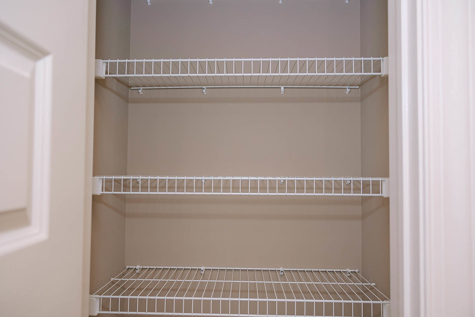 White wire shelving mounted on a white closet wall with smooth painted finish.