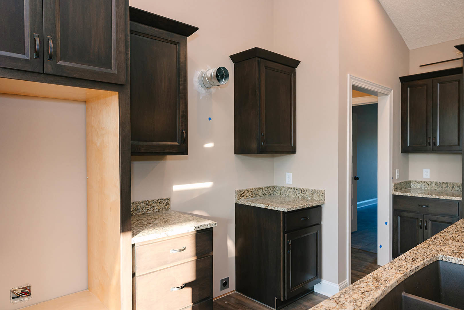 Kitchen featuring dark wood cabinets, polished granite countertops, stainless steel appliances, and a deep undermount sink