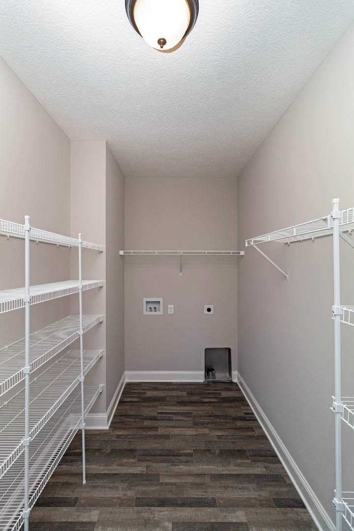 Walk-in closet with wood flooring, white baseboards, white wire shelving, and a ceiling light fixture