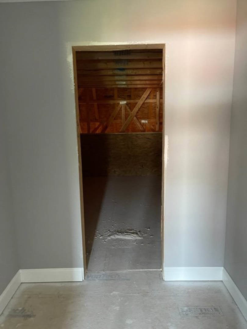 White plaster walls and ceiling with a smooth concrete floor, featuring a minimalist doorway leading to an adjacent room