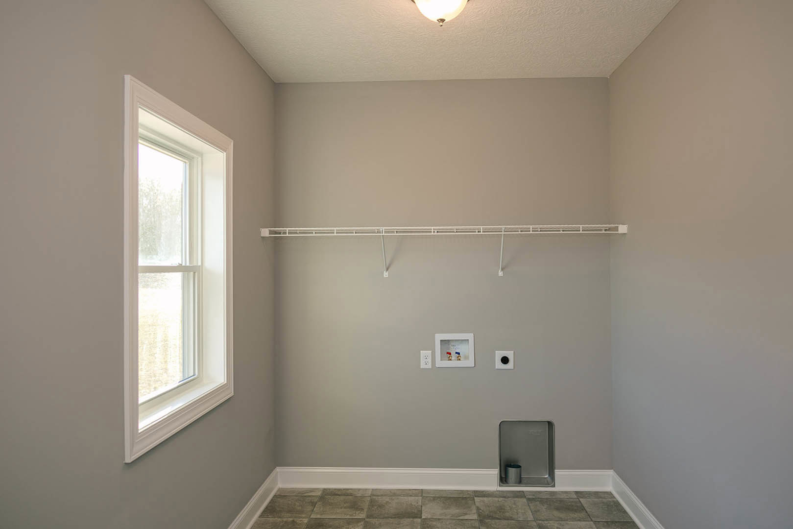 Bathroom with white tile walls, built-in white shelf, glass window, metal shower fixture, and white ceiling.