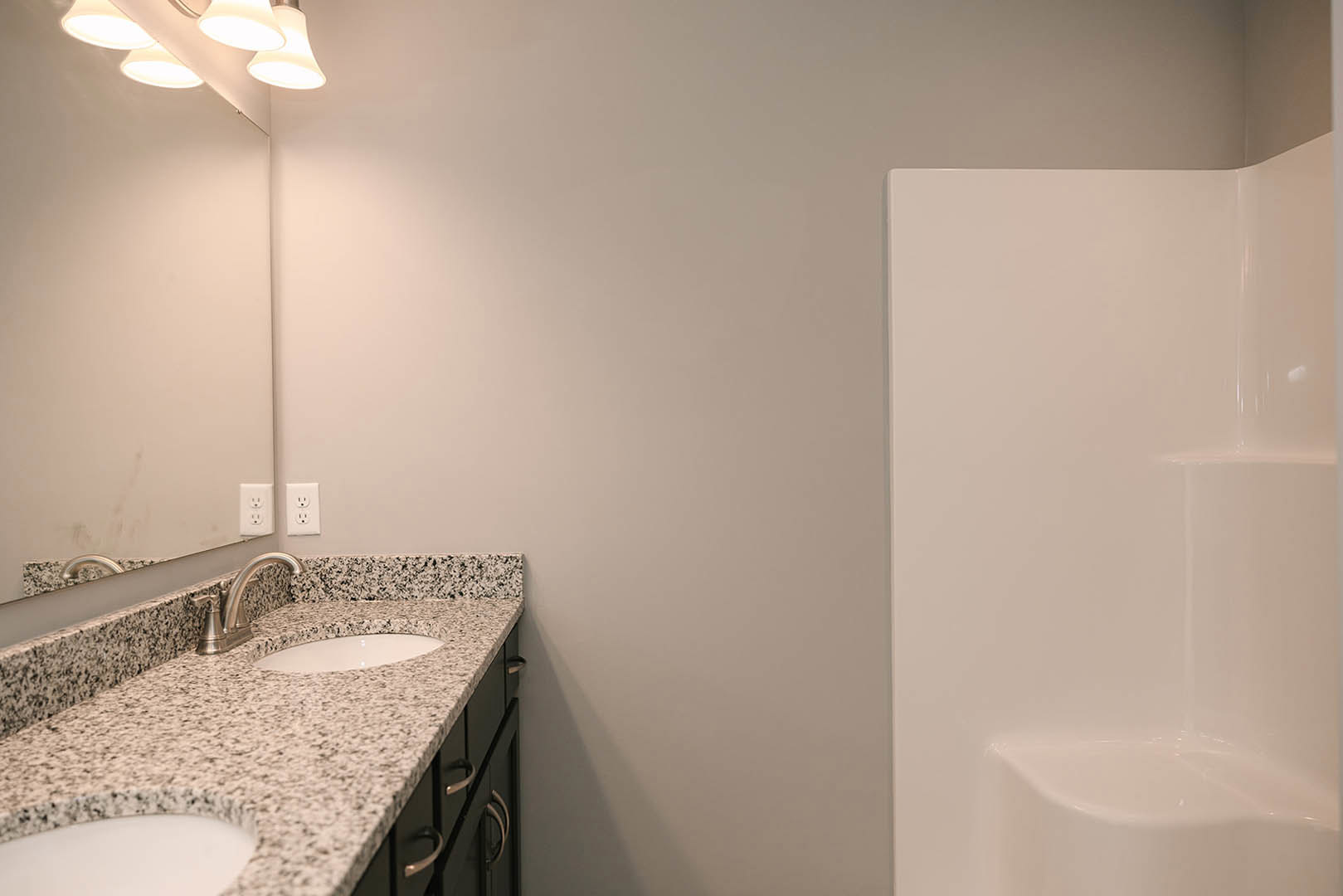Marble bathroom countertop with undermount sink, chrome faucet, tile backsplash, and wall outlet visible