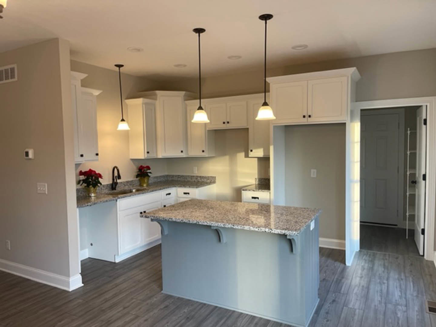 Granite countertops, white tile backsplash, wood cabinetry, stainless steel sink, and large window in modern kitchen