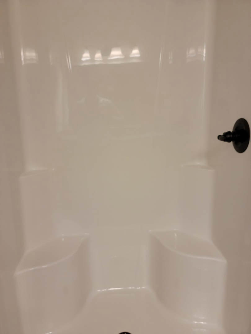 White tile shower with matte black handle and faucet