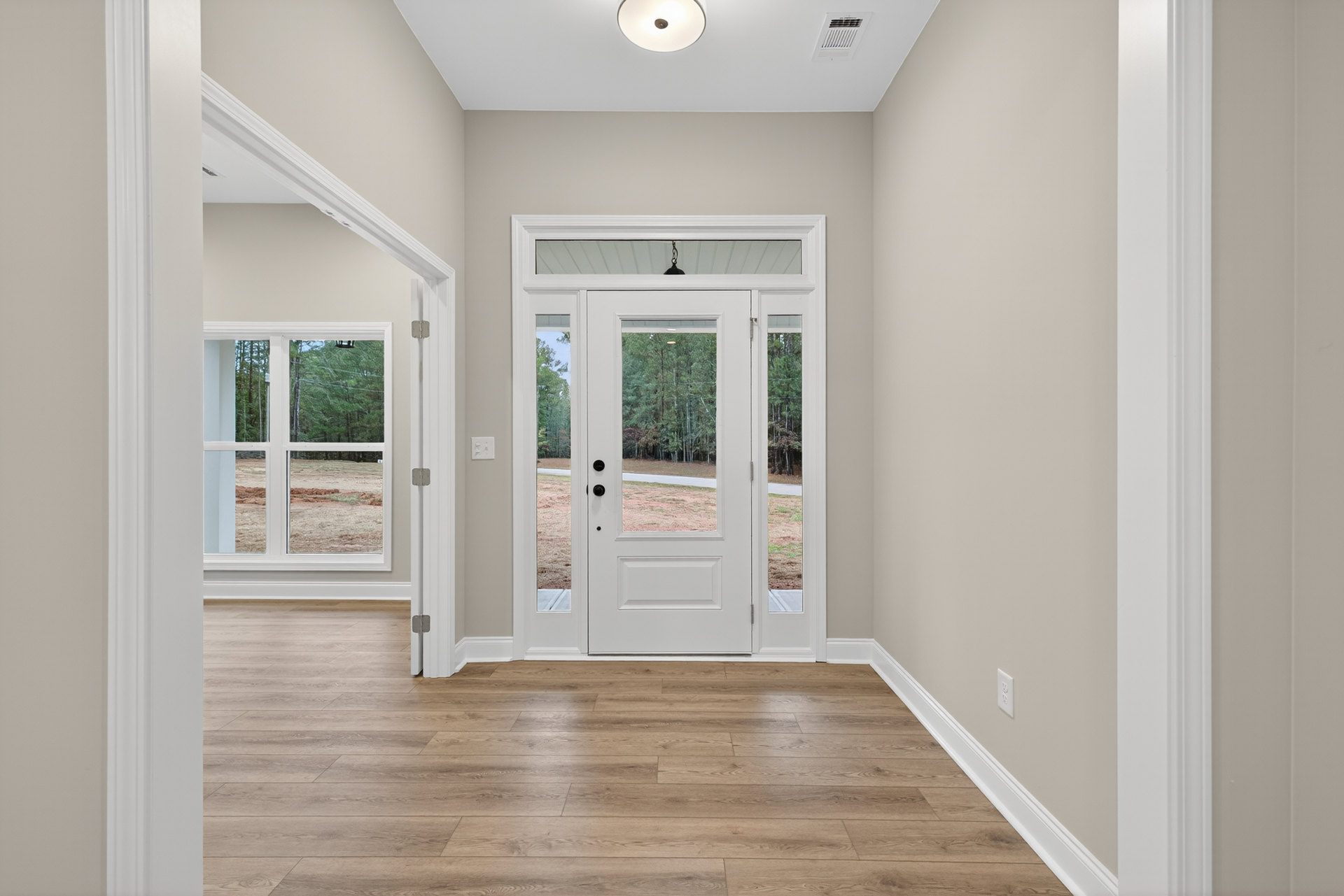 White paneled door with glass inserts, wood flooring, white walls, ceiling light fixture, and decorative molding