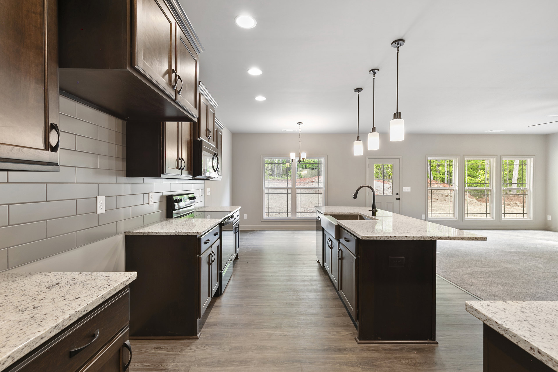 Marble kitchen countertops, wood flooring, white cabinetry, stainless steel stove, and modern sink fixtures