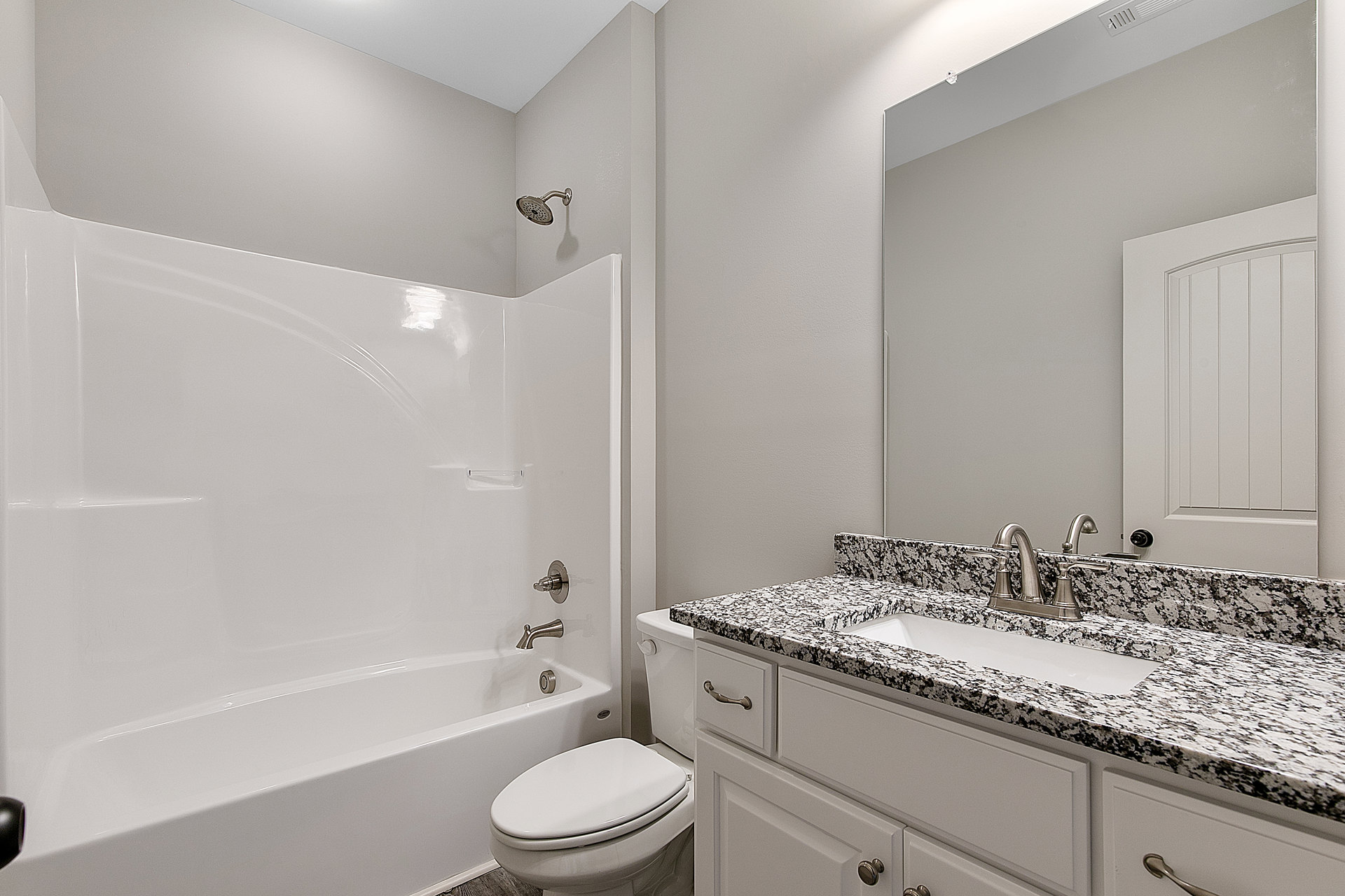 Modern bathroom with white porcelain sink, chrome faucet, and matching toilet against light tile walls