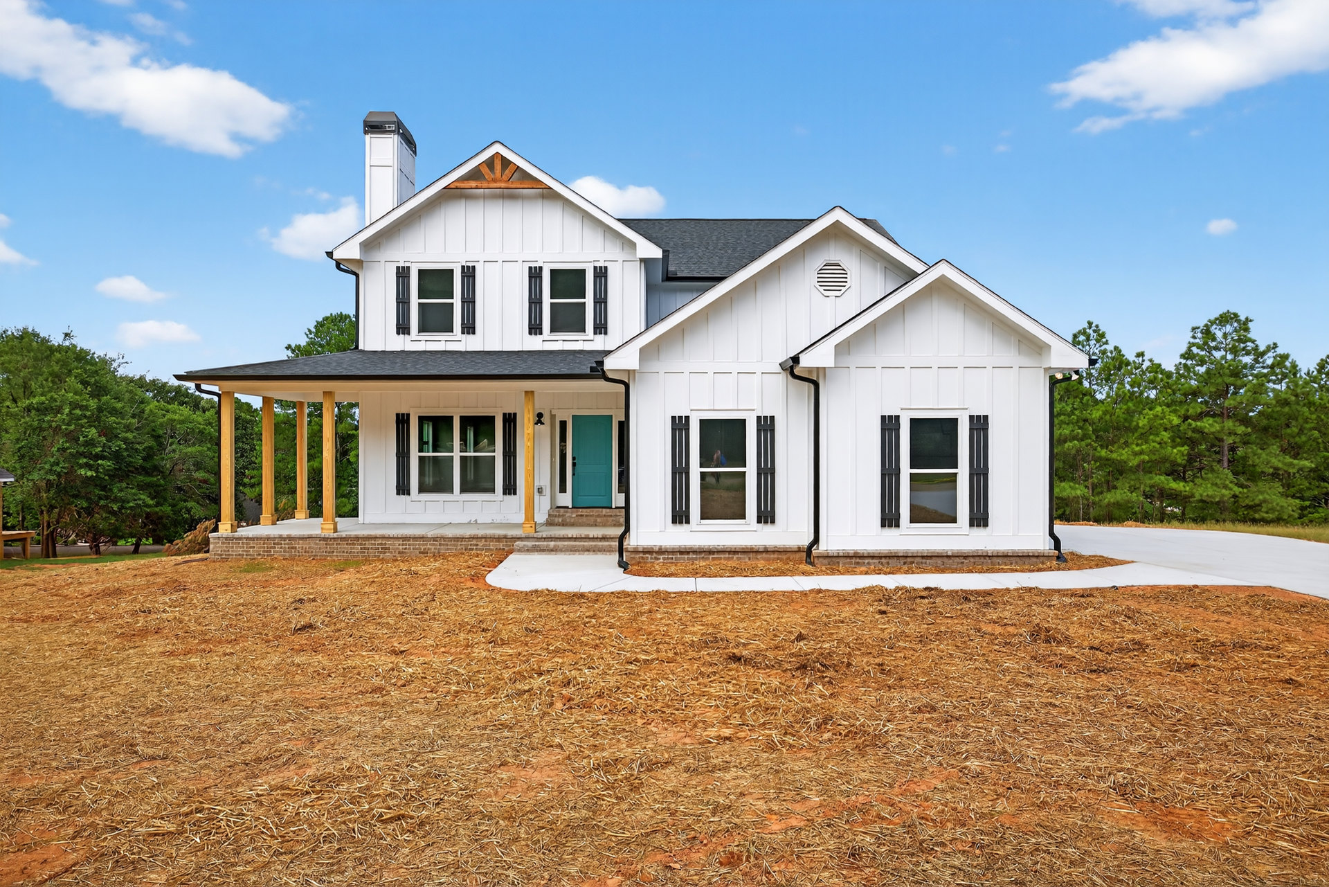 White siding house with blue front door, covered porch, white trim, and windows under a partly cloudy sky