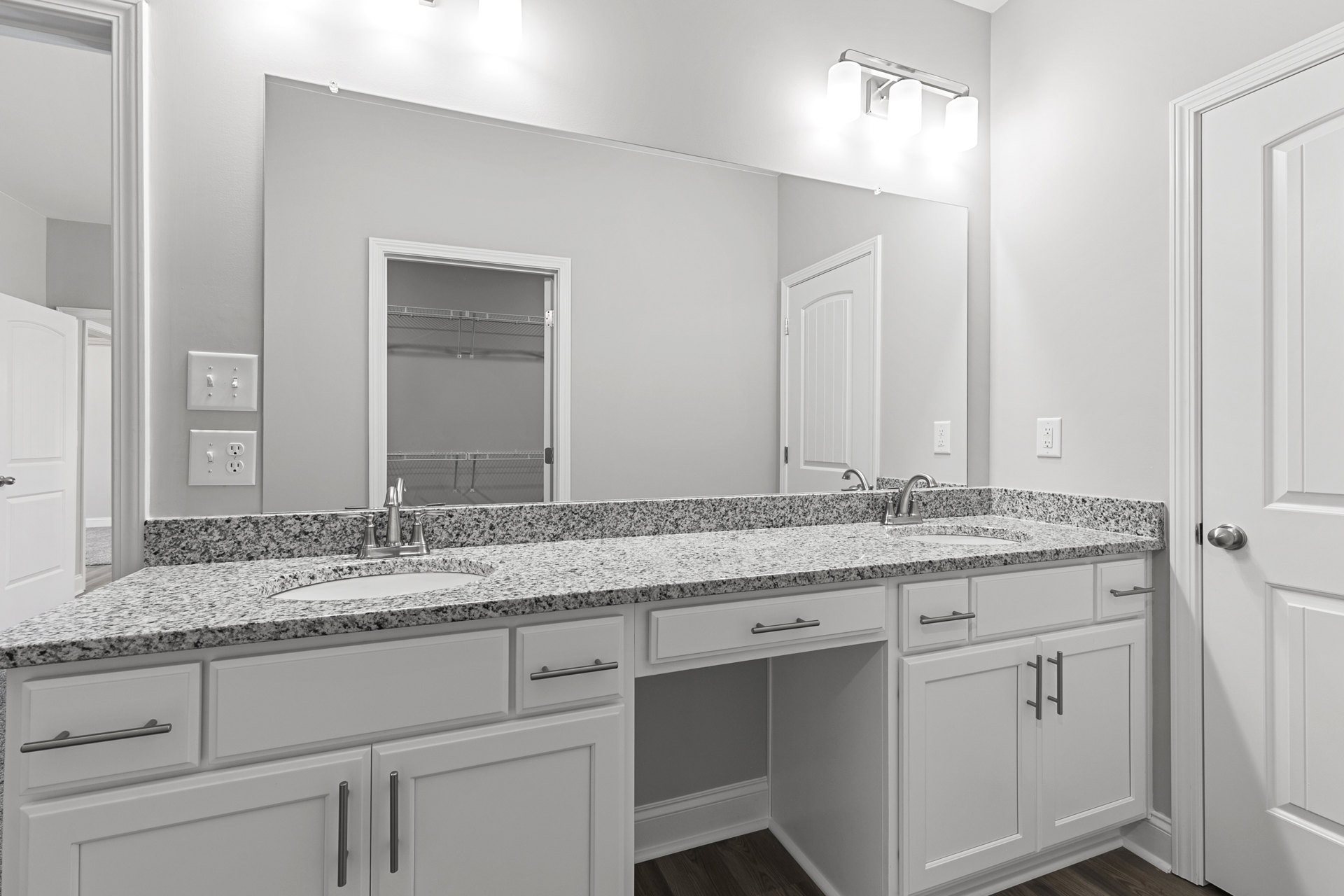 Bathroom with marble countertop, white cabinetry, chrome faucet, and tiled backsplash