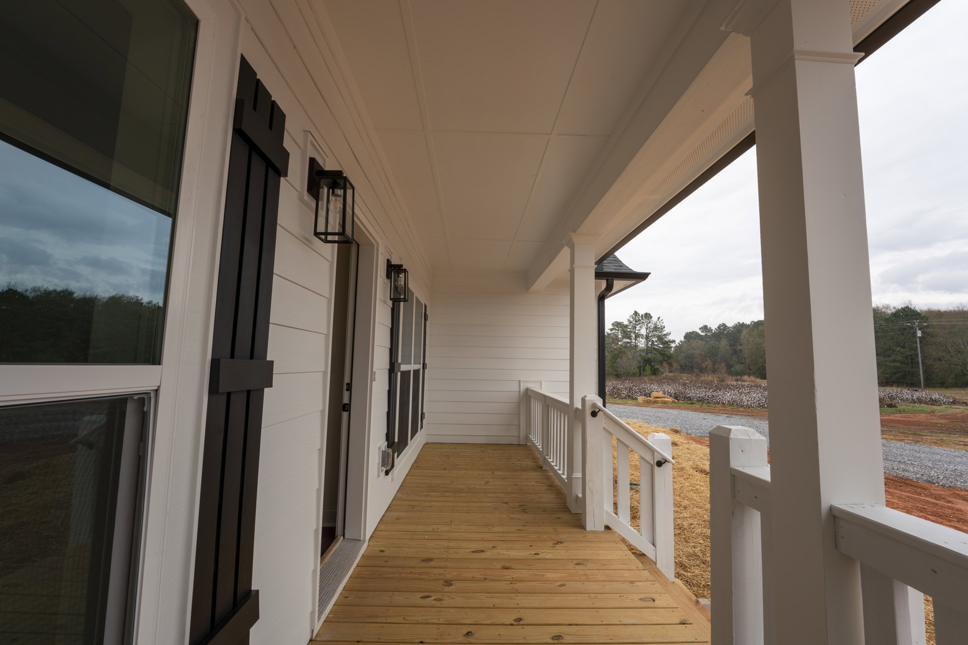 Wood deck porch with white railing, screened area, and bird perched on mesh