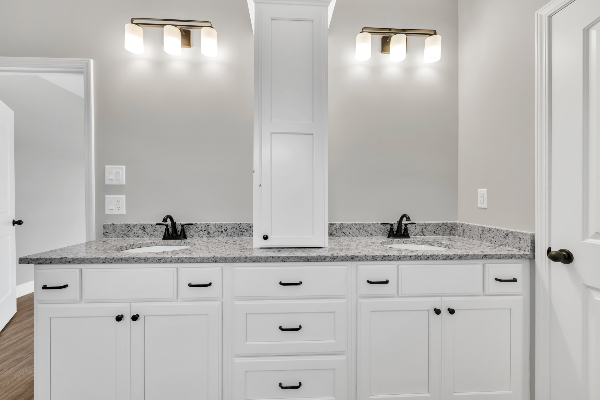 Bathroom featuring white shaker cabinets, marble countertops, chrome faucet, and tiled backsplash.