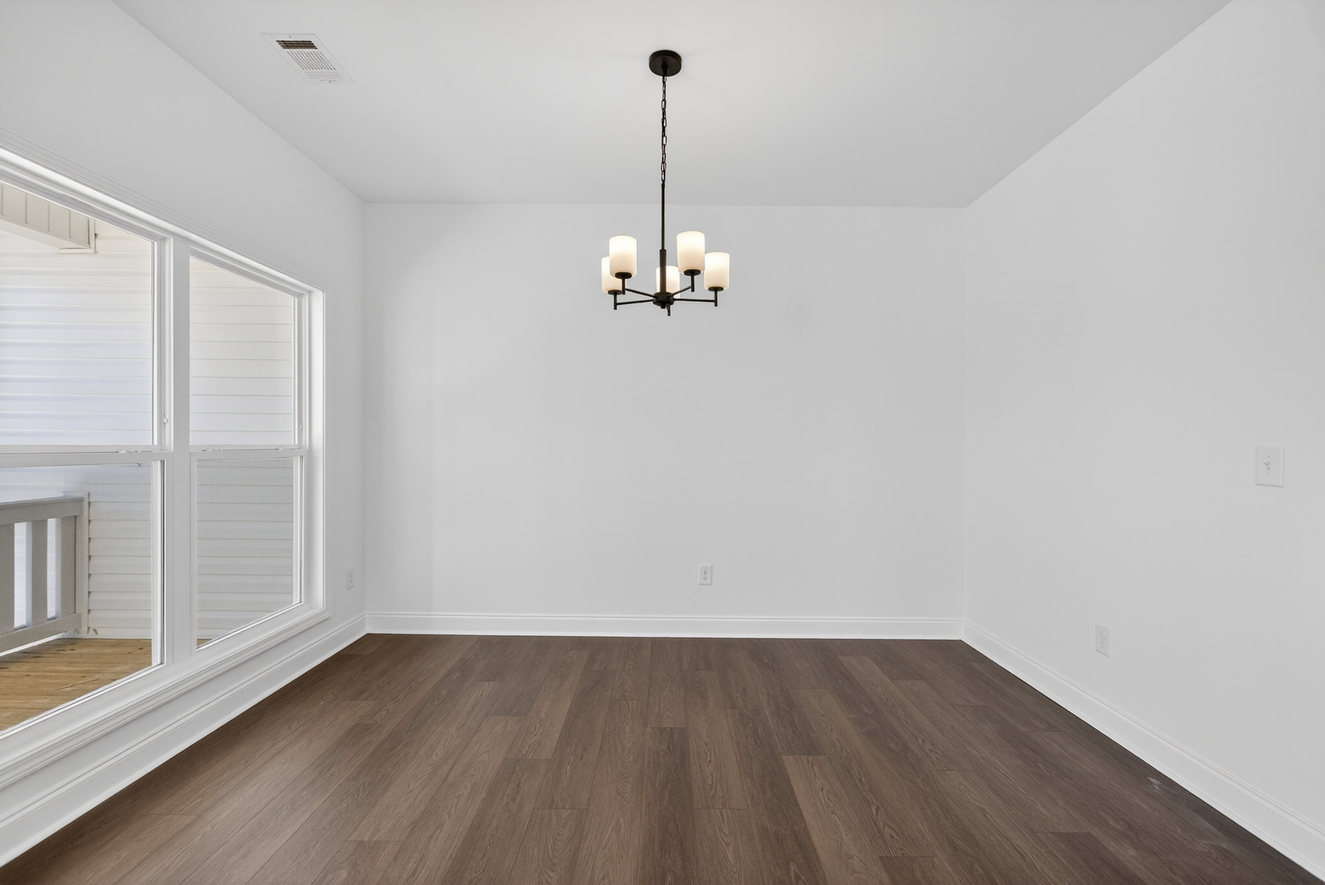 Chandelier with two white lamps hanging in a room featuring wood flooring, white trim, white plaster walls, and a window with blinds