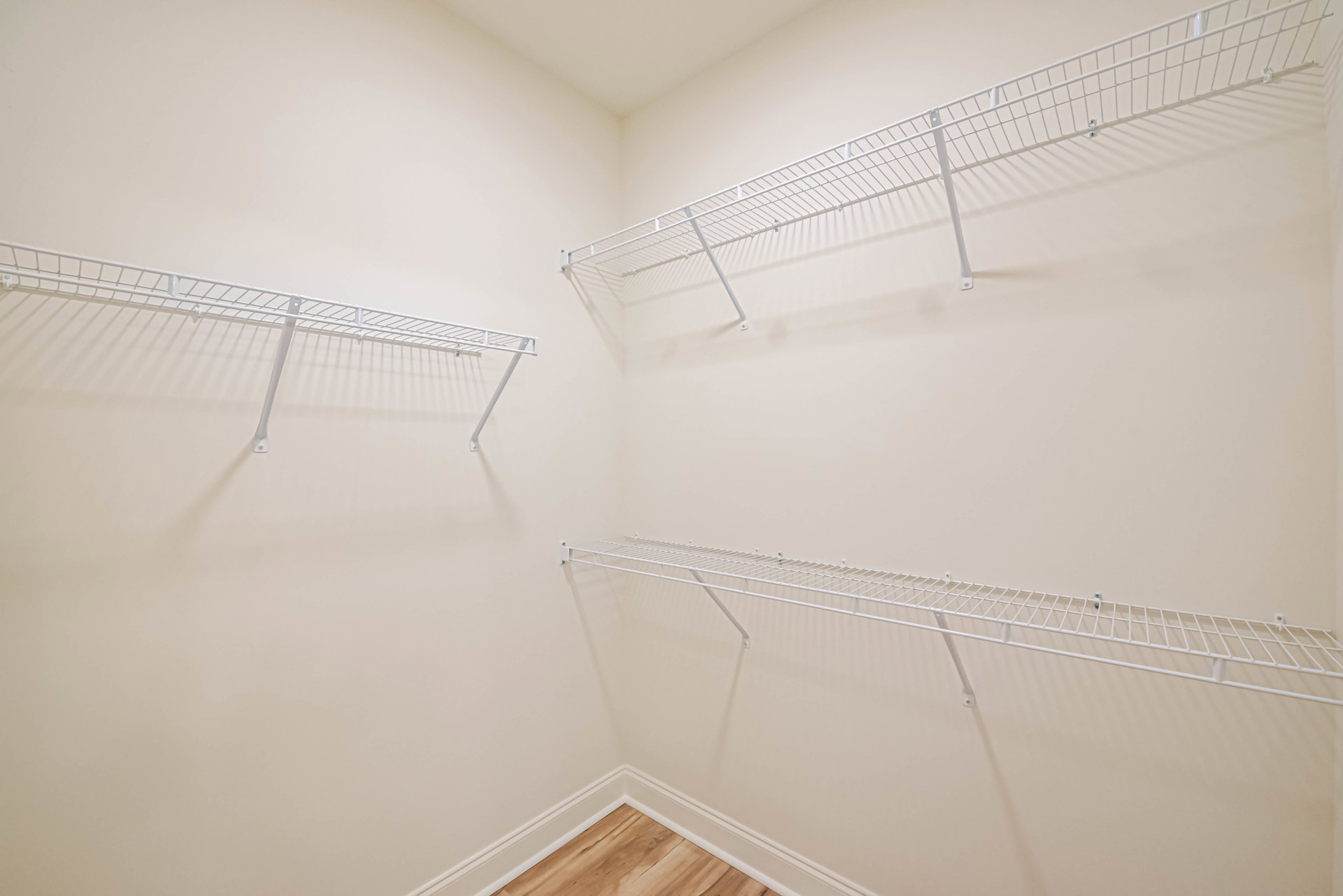 White built-in shelves on plaster wall beside staircase in modern residential interior