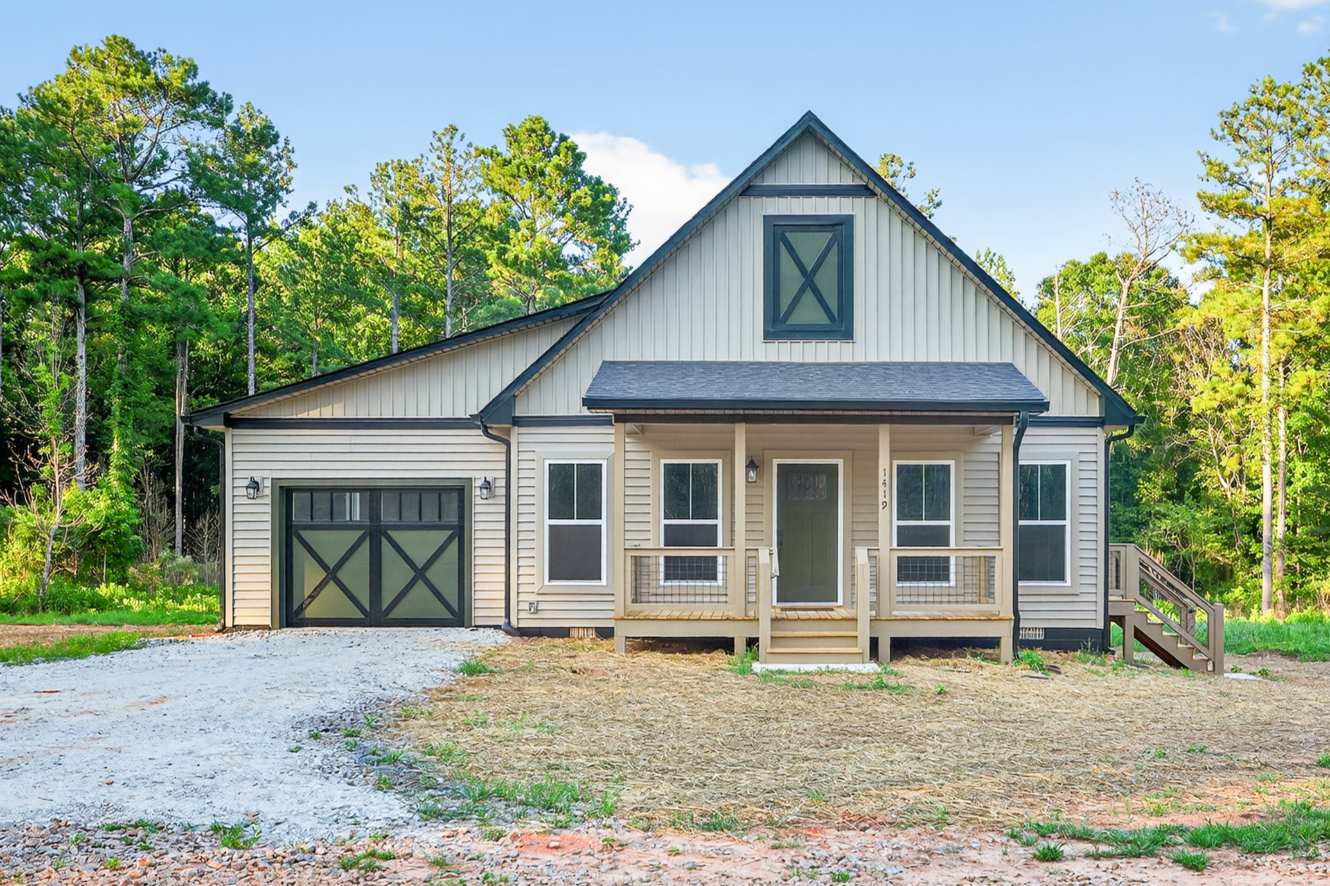 Two-story house with attached garage, gravel driveway, white siding, blue front door, covered porch, and landscaped front yard with trees and shrubs
