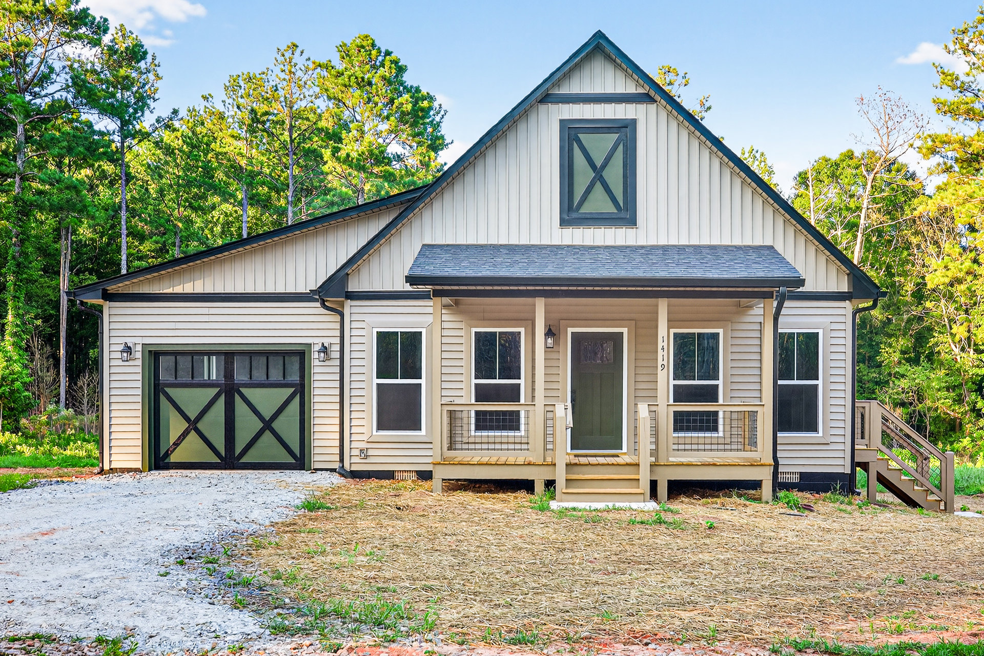 Two-story home with green and black garage door, concrete driveway, exterior staircase, green front door with window, blue X marking on upper window, surrounded by trees and