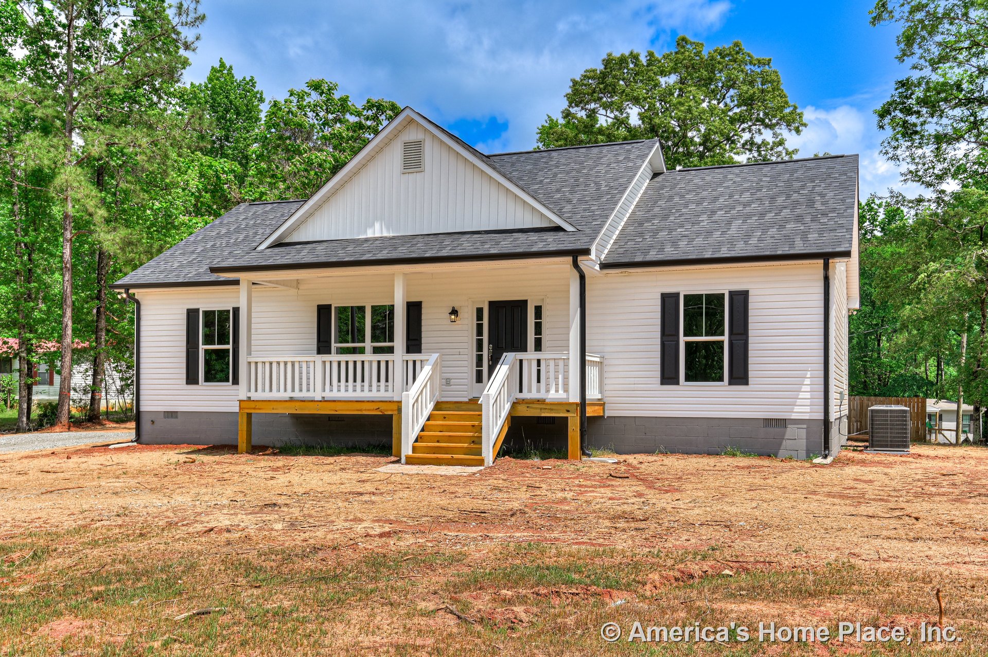 Single-story home with white horizontal siding, black window shutters, gray shingle roof, and a covered front porch featuring white wood railings, wooden steps, and a black front