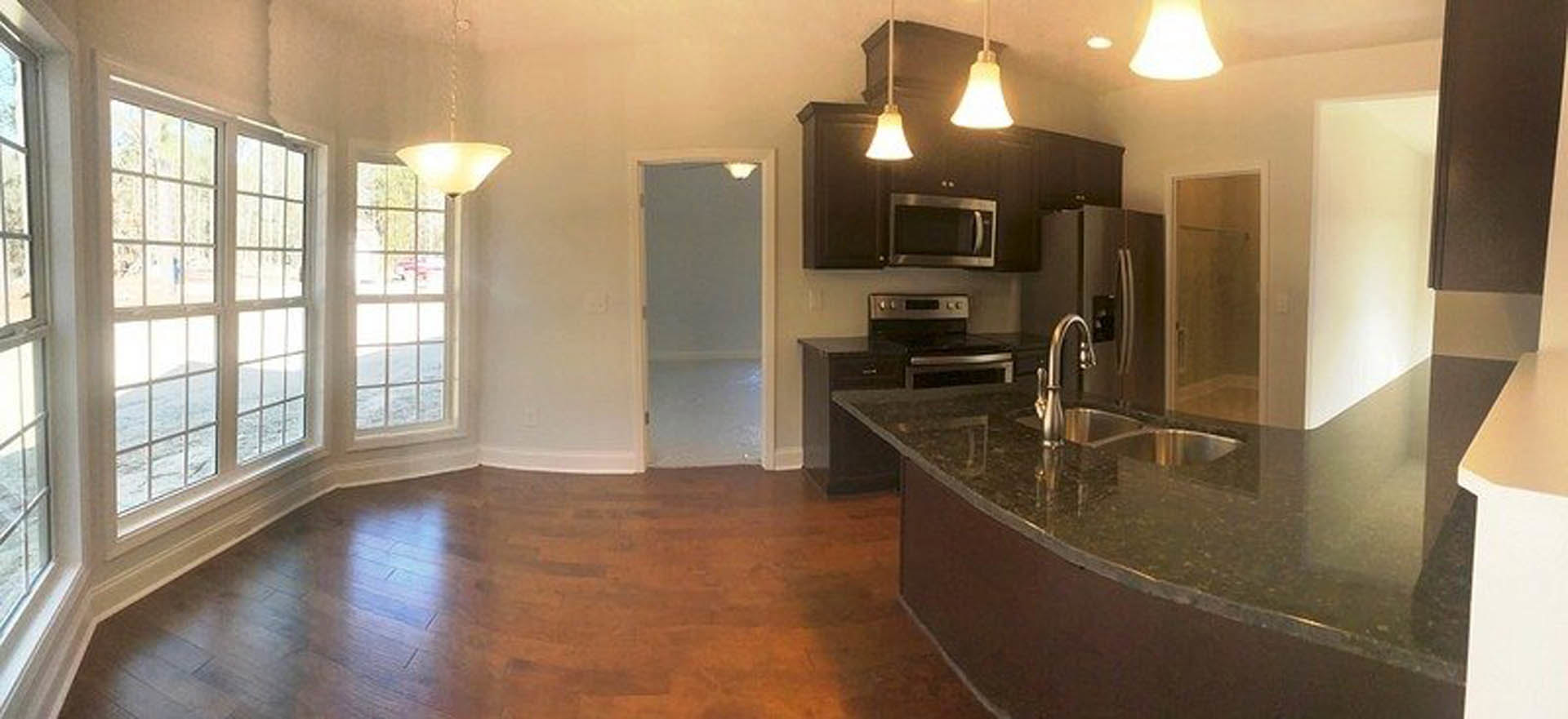 Marble kitchen island with integrated sink and faucet, stainless steel refrigerator, white cabinetry, tile flooring, and ceiling light fixture