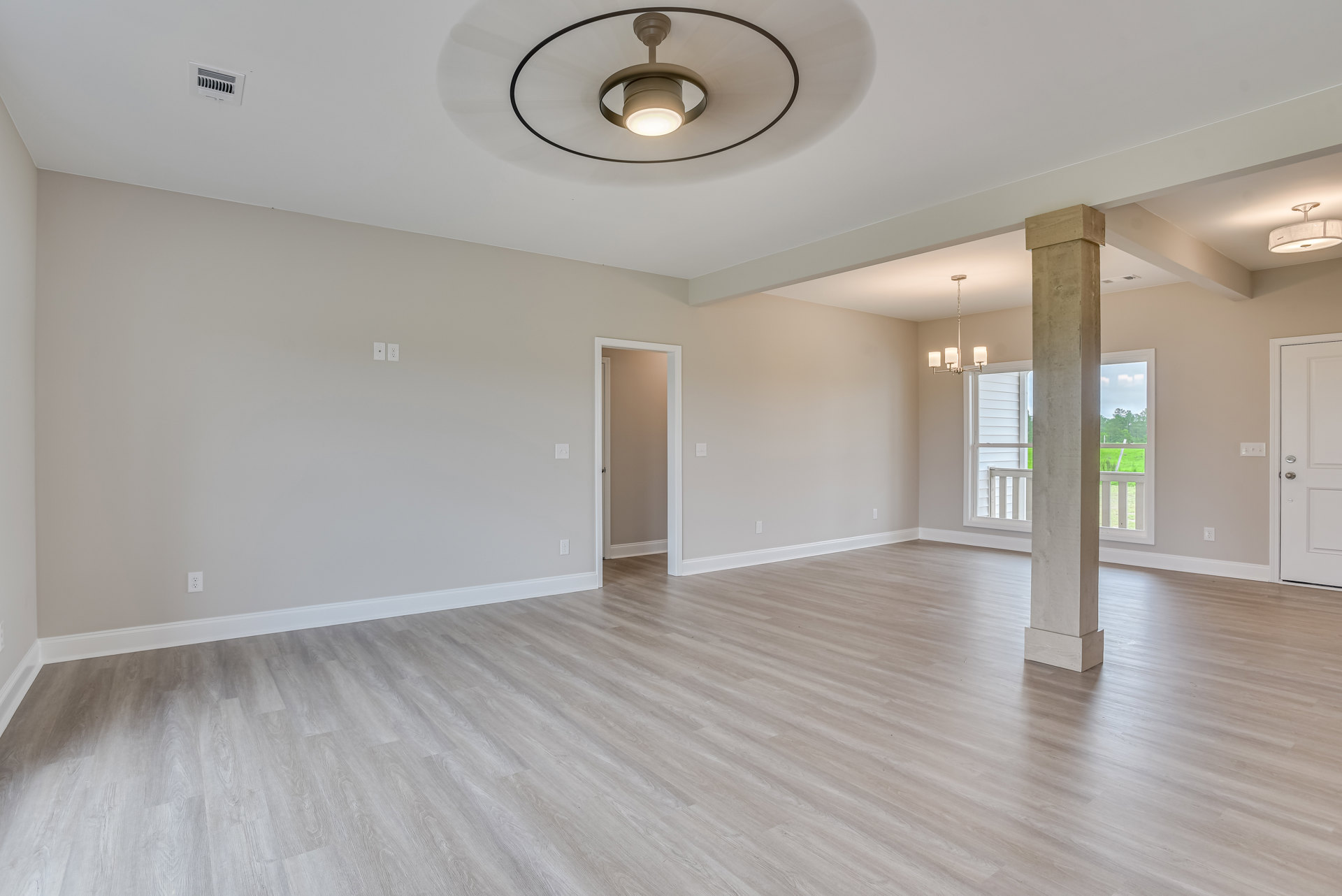 Ceiling fan with light fixture, hardwood floor, white walls, white door, wall vent