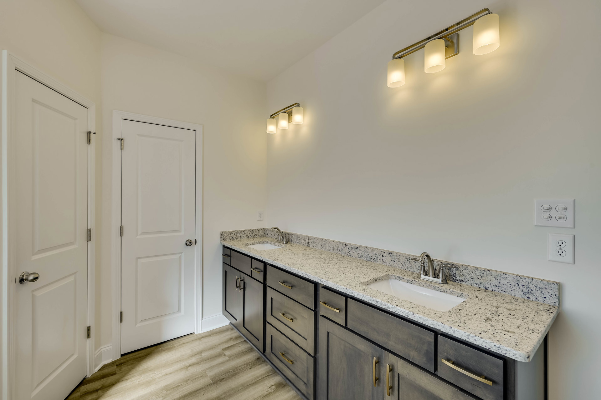 Marble countertop with undermount sink and chrome faucet, white cabinetry, white door with silver knob and metal hinge, light tile flooring