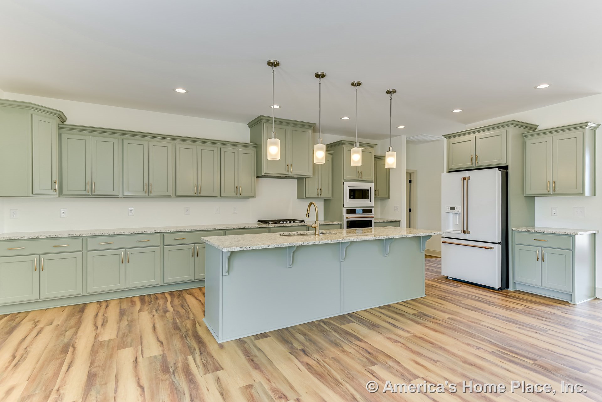 Sage green cabinetry and a large kitchen island with granite countertops, pendant lighting above, wood-look flooring, built-in double oven, stainless refrigerator, and open layout