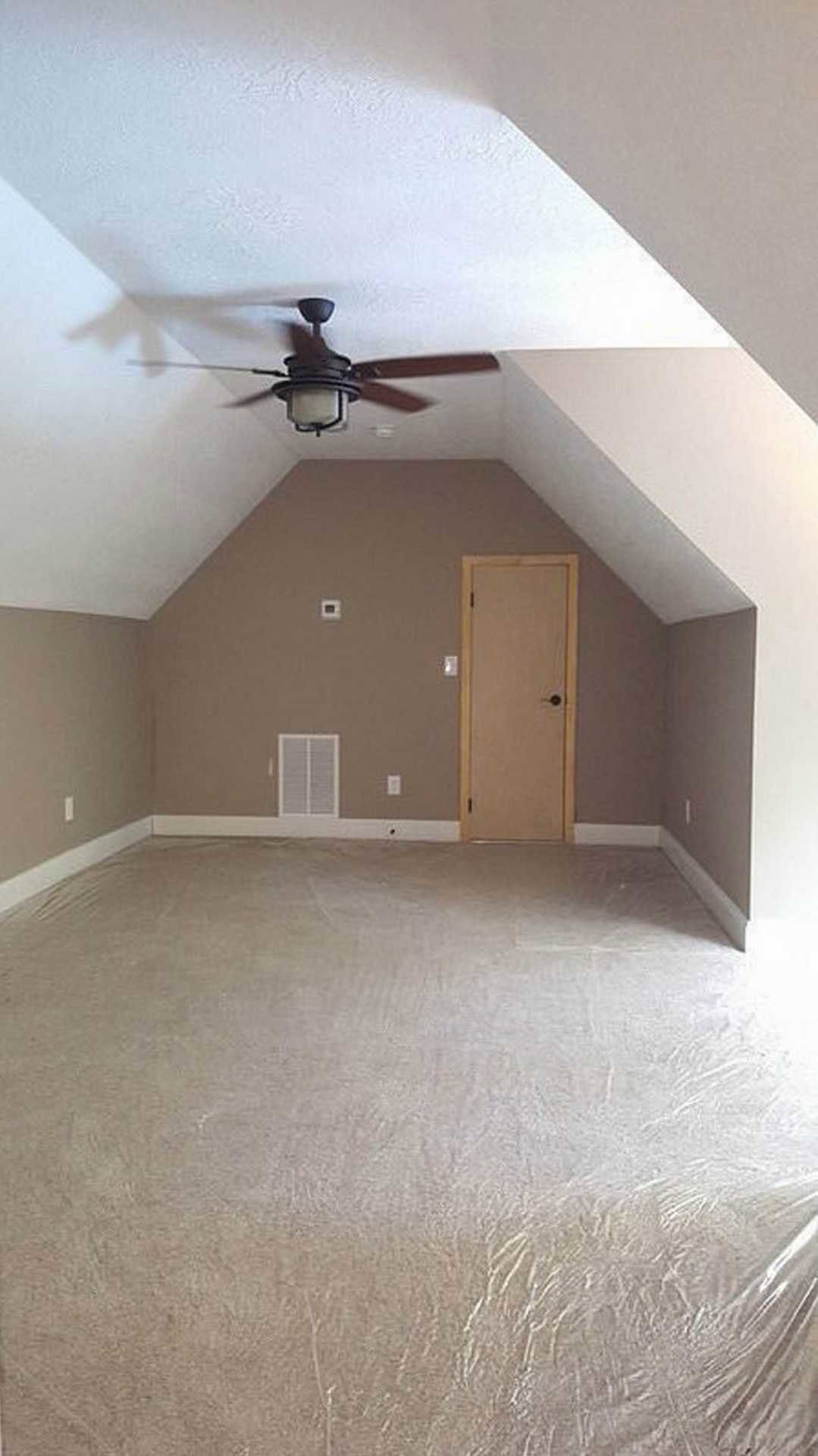 Ceiling fan with integrated light fixture mounted on white plaster ceiling above neutral-toned flooring, adjacent to two white doors and smooth walls.