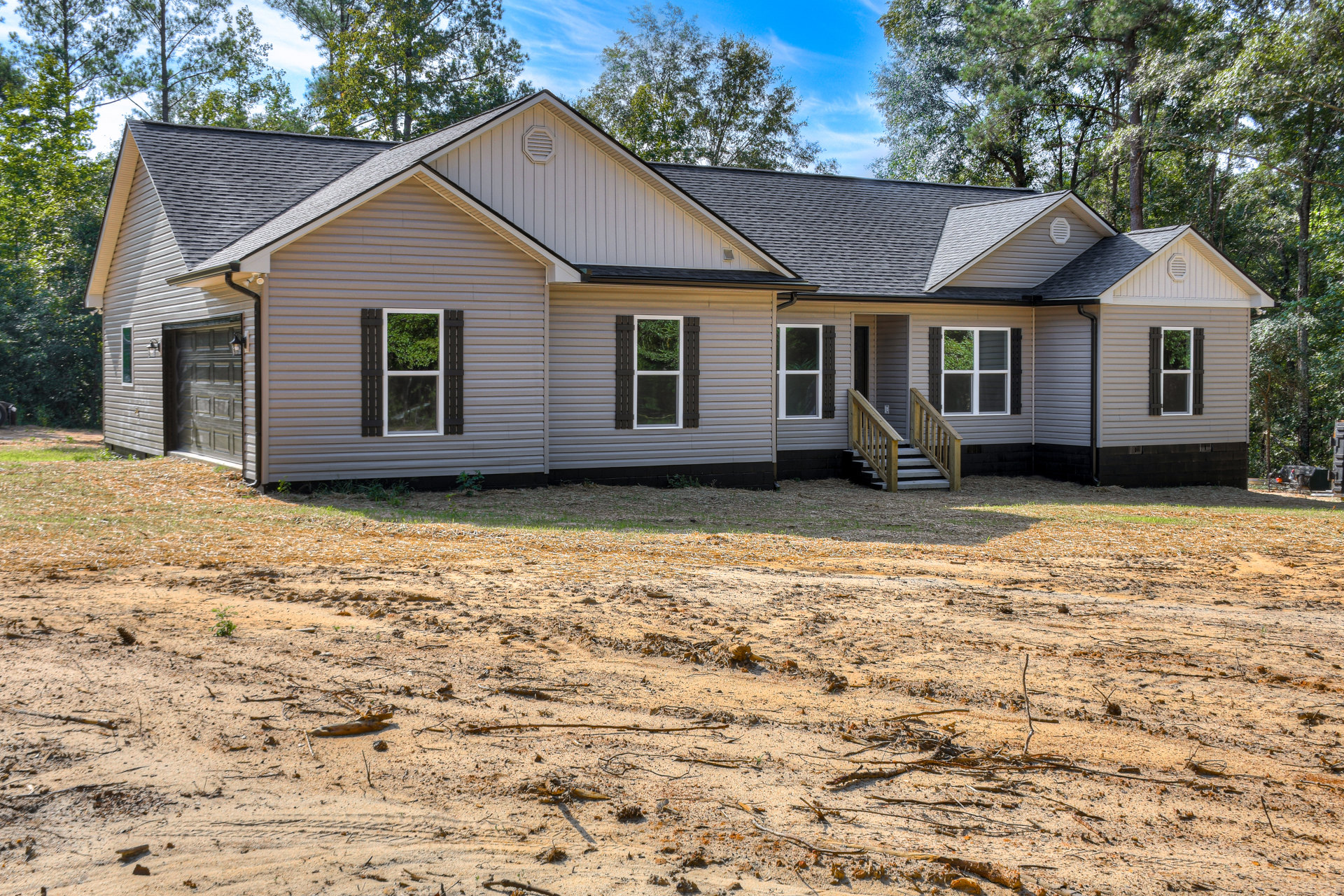 Two-story house with white siding, covered porch, exterior stairs, dirt yard, and green tree visible through windows