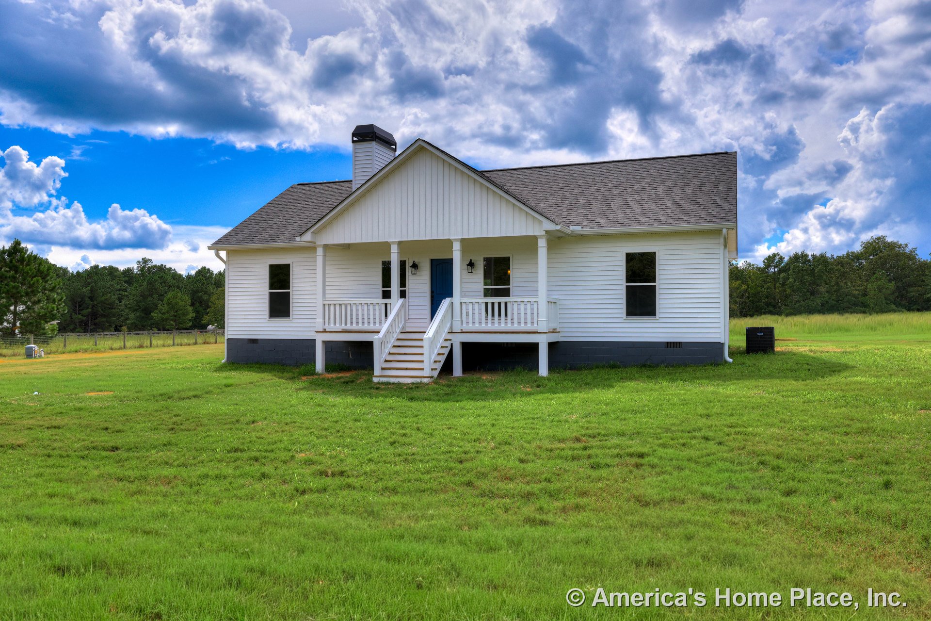 Covered front porch with double white columns and railings, white horizontal siding, gabled shingle roof with chimney, black foundation trim, front steps, and multiple windows.