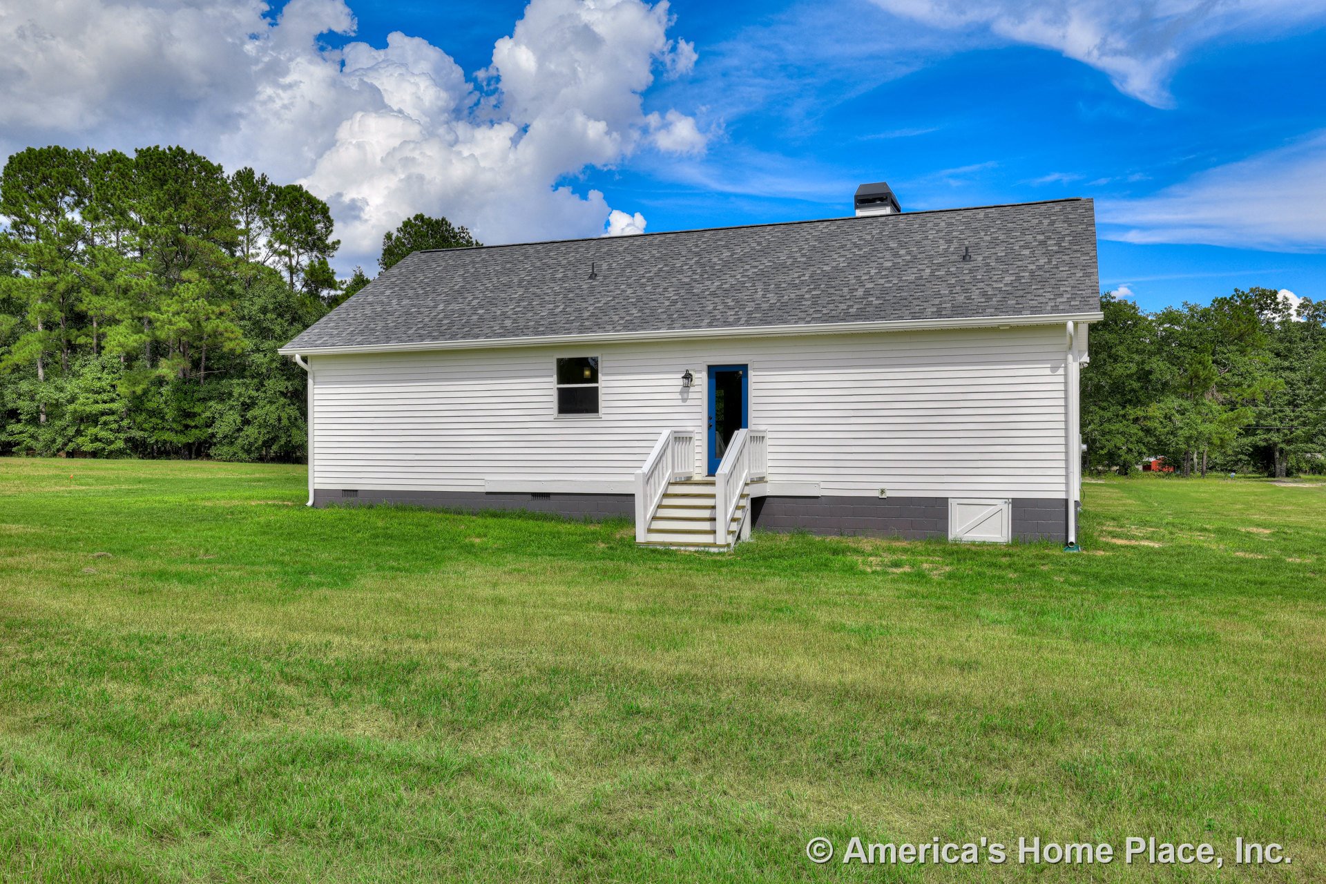 White horizontal vinyl siding exterior with gray shingle roof, small entry porch featuring steps, single exterior door, raised foundation, outdoor light fixture, and simple window