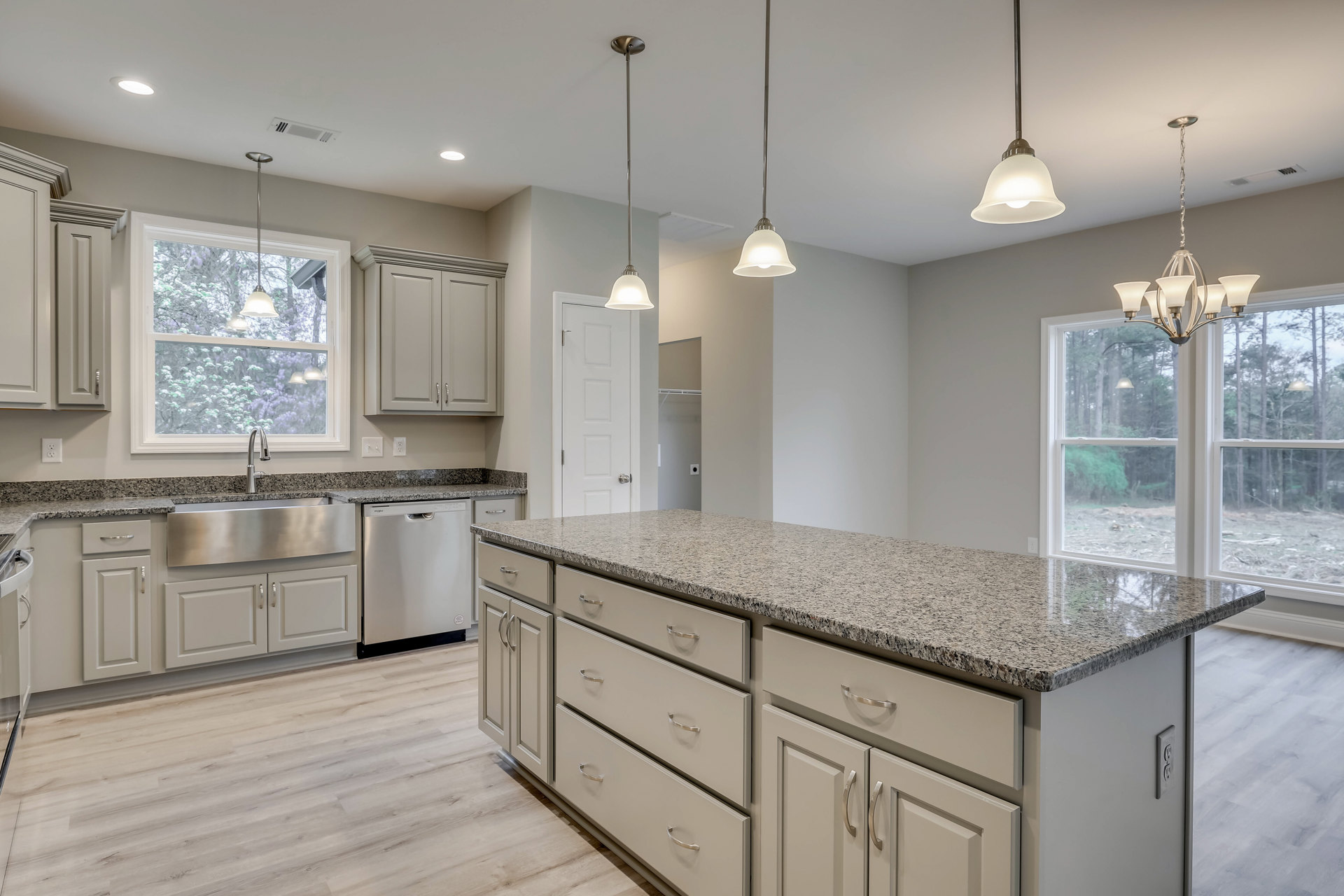 Granite countertops, stainless steel appliances, tile backsplash, window above sink with modern faucet, cabinetry and drawers, built-in dishwasher, close-up of stainless steel sink