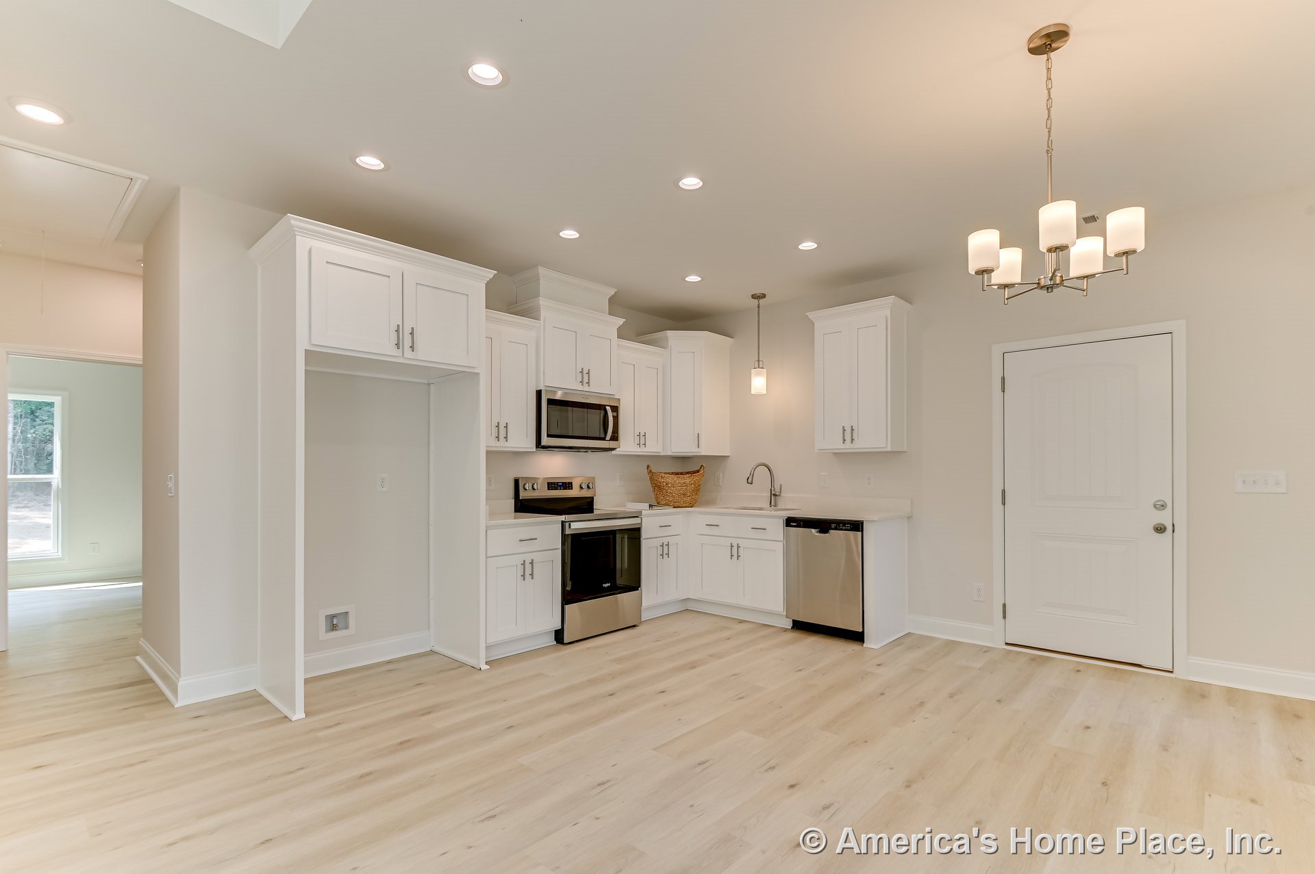 White shaker cabinets with stainless steel oven, microwave, and built-in dishwasher; light wood plank flooring; recessed ceiling lights; modern chandelier above adjacent dining