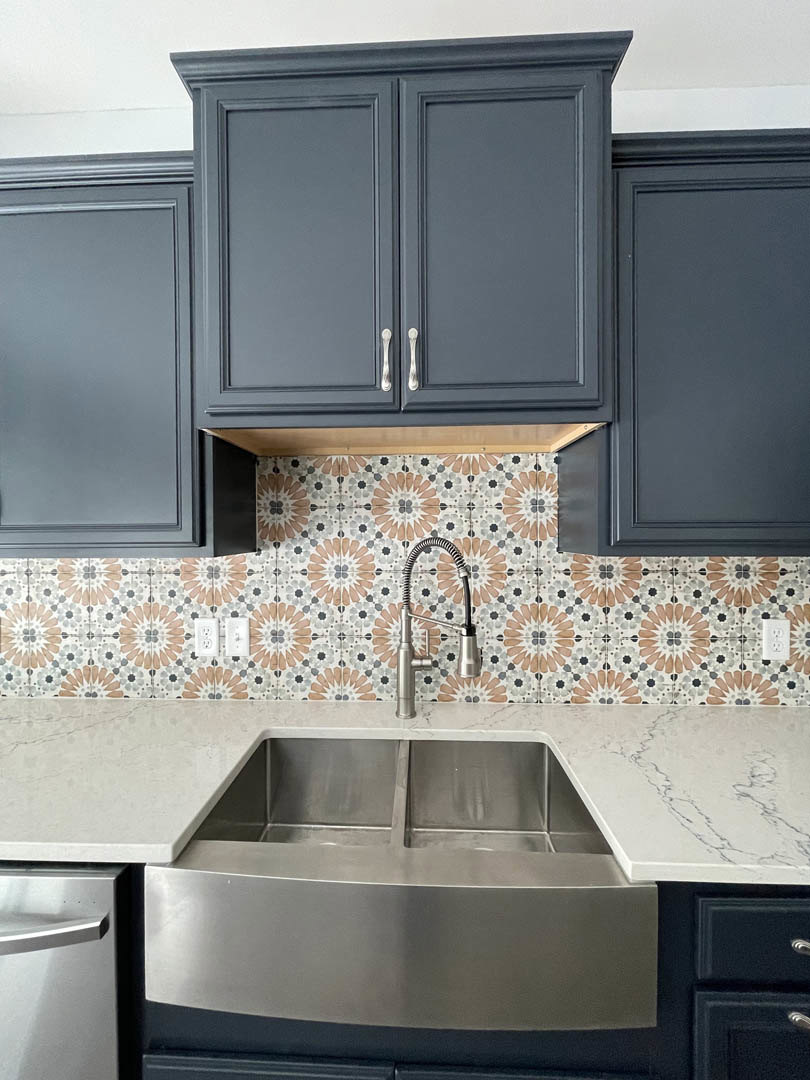 Granite countertop kitchen with stainless steel double sink, brushed metal faucet, grey cabinetry, and built-in appliances