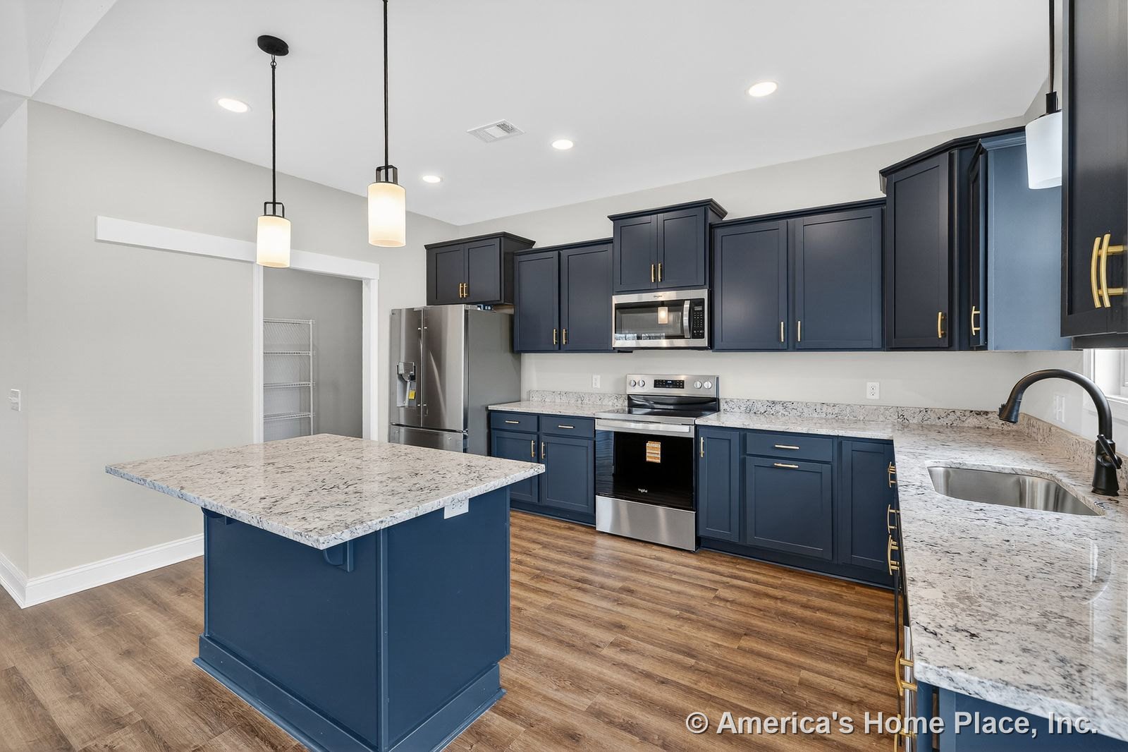Navy shaker cabinets with granite countertops, stainless steel appliances, pendant lighting, wood-look flooring, undermount sink, and pantry with sliding door.
