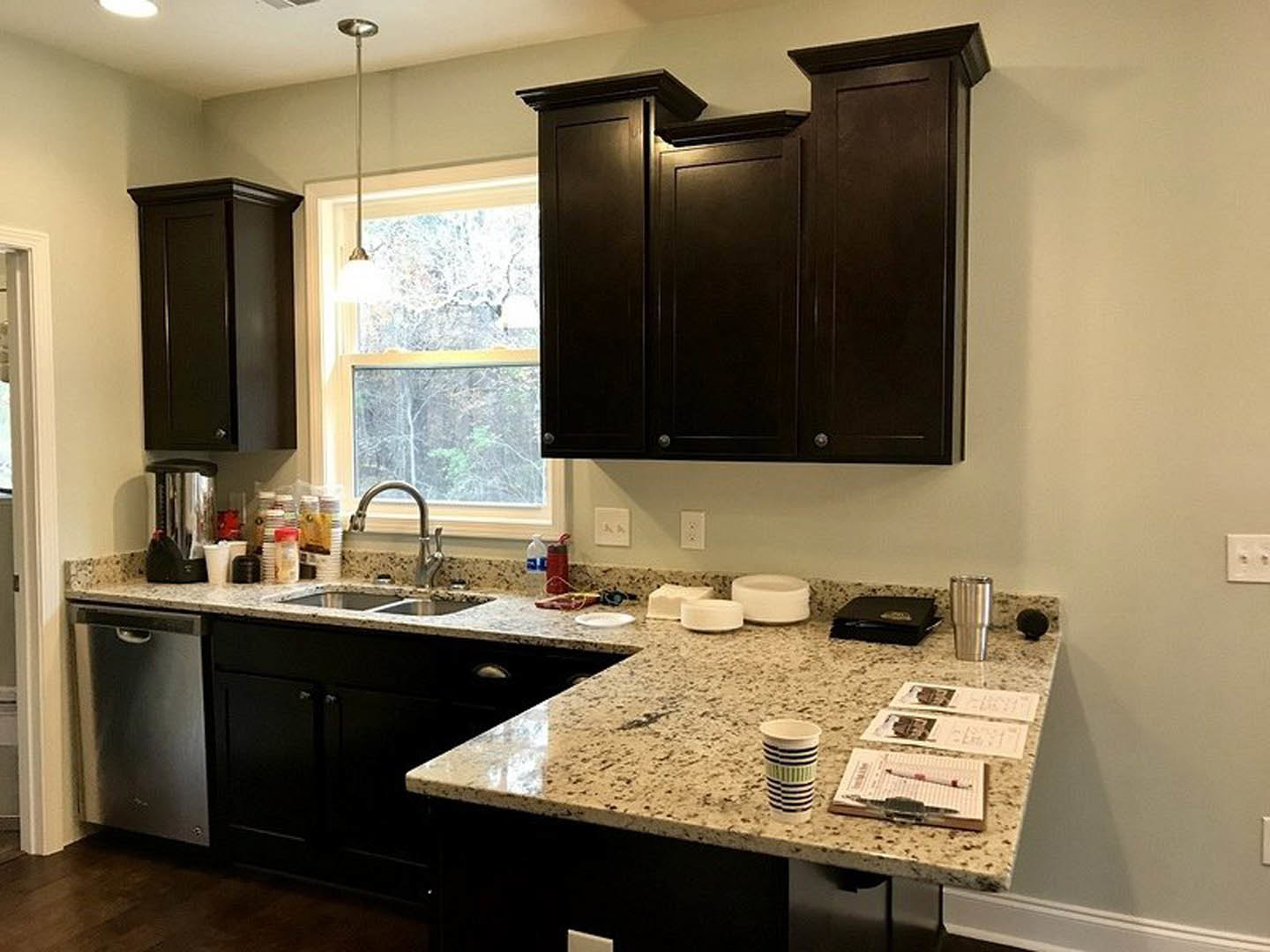 Modern kitchen featuring matte black cabinets, white quartz countertops, stainless steel appliances, and a large undermount sink with chrome faucet.