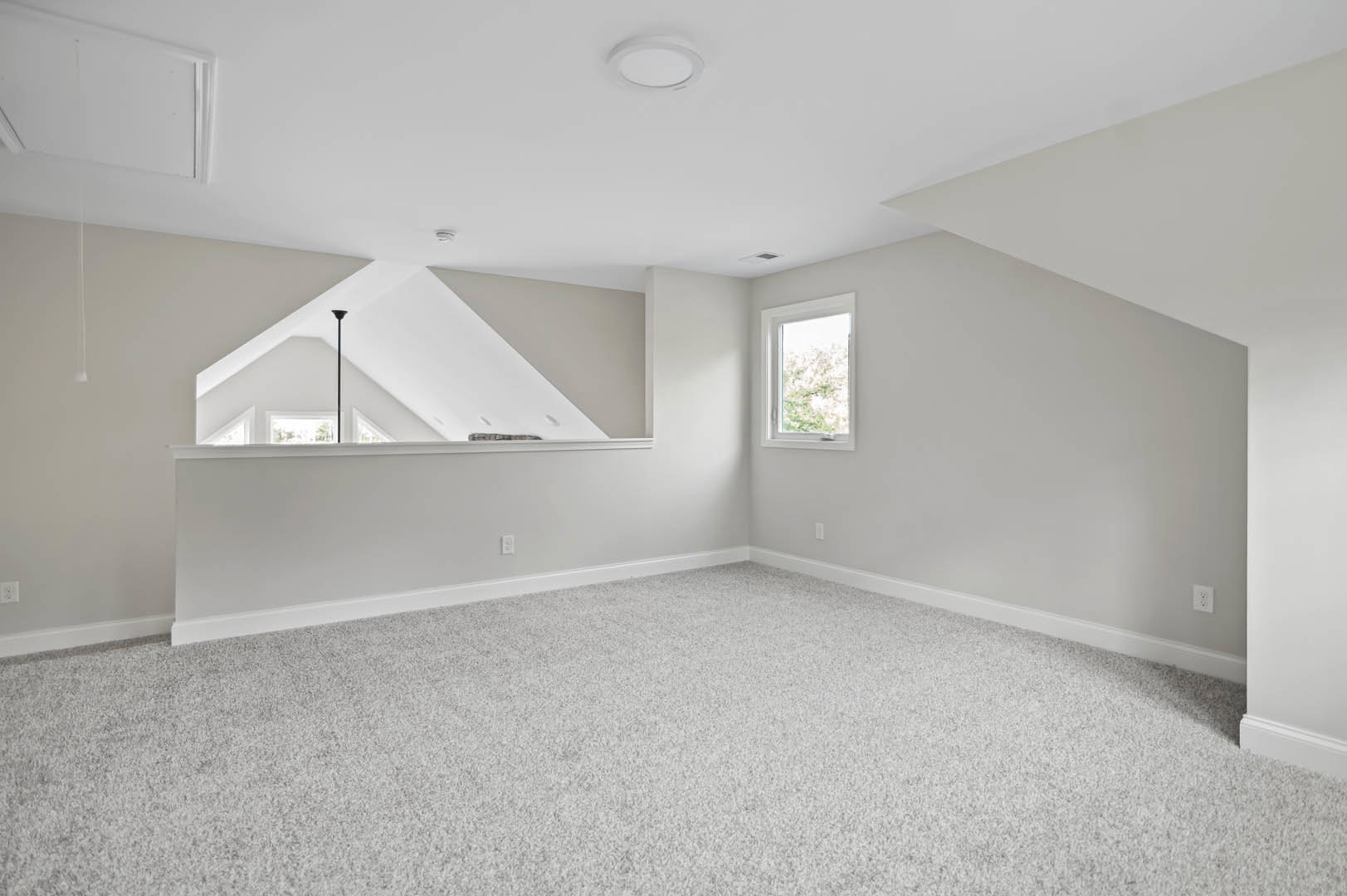 White carpeted floor in a room with white walls, window with white frame, ceiling light fixture, and wall mirror